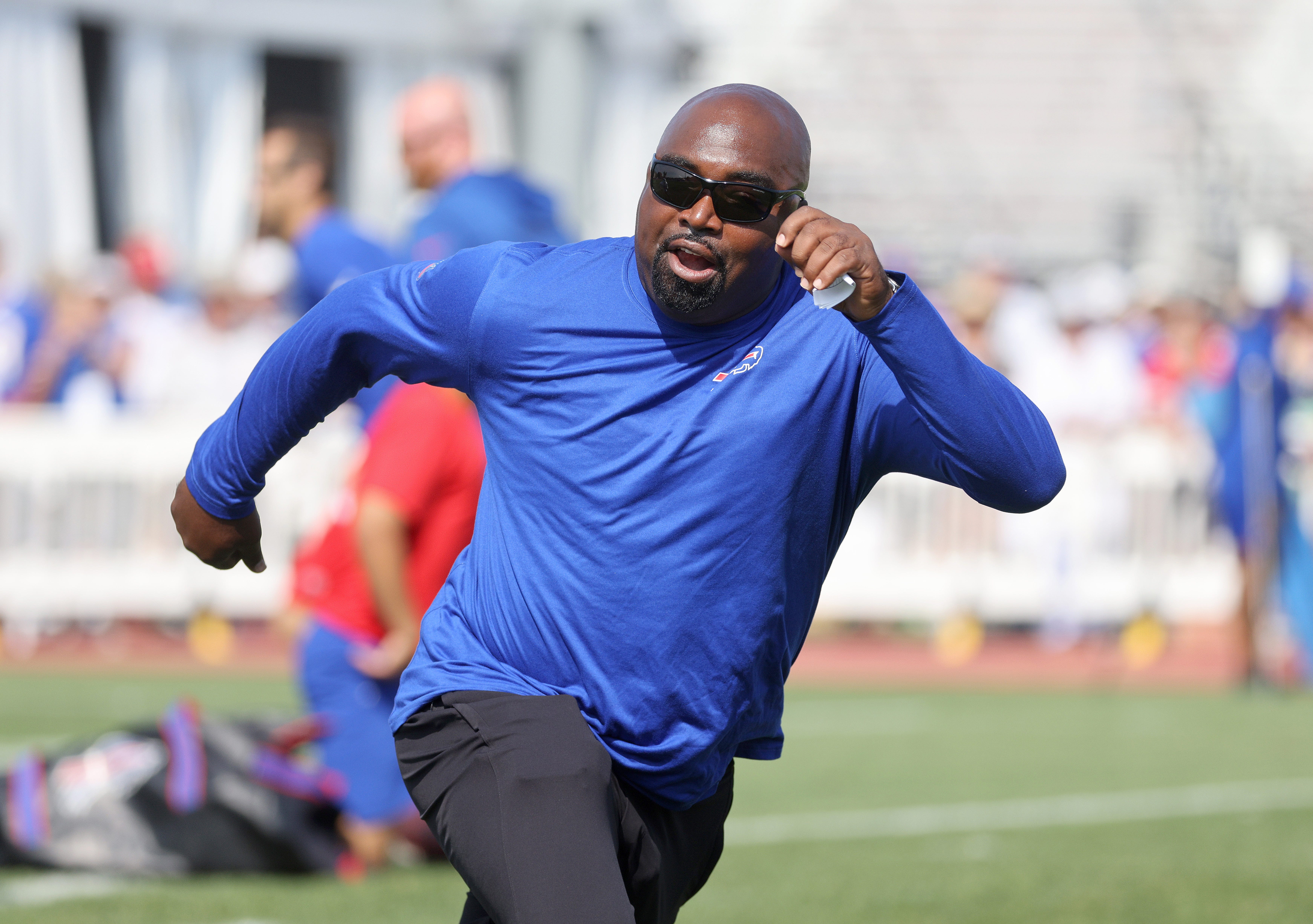 Wide receiver coach Adam Henry covers a receiver during passing drills.