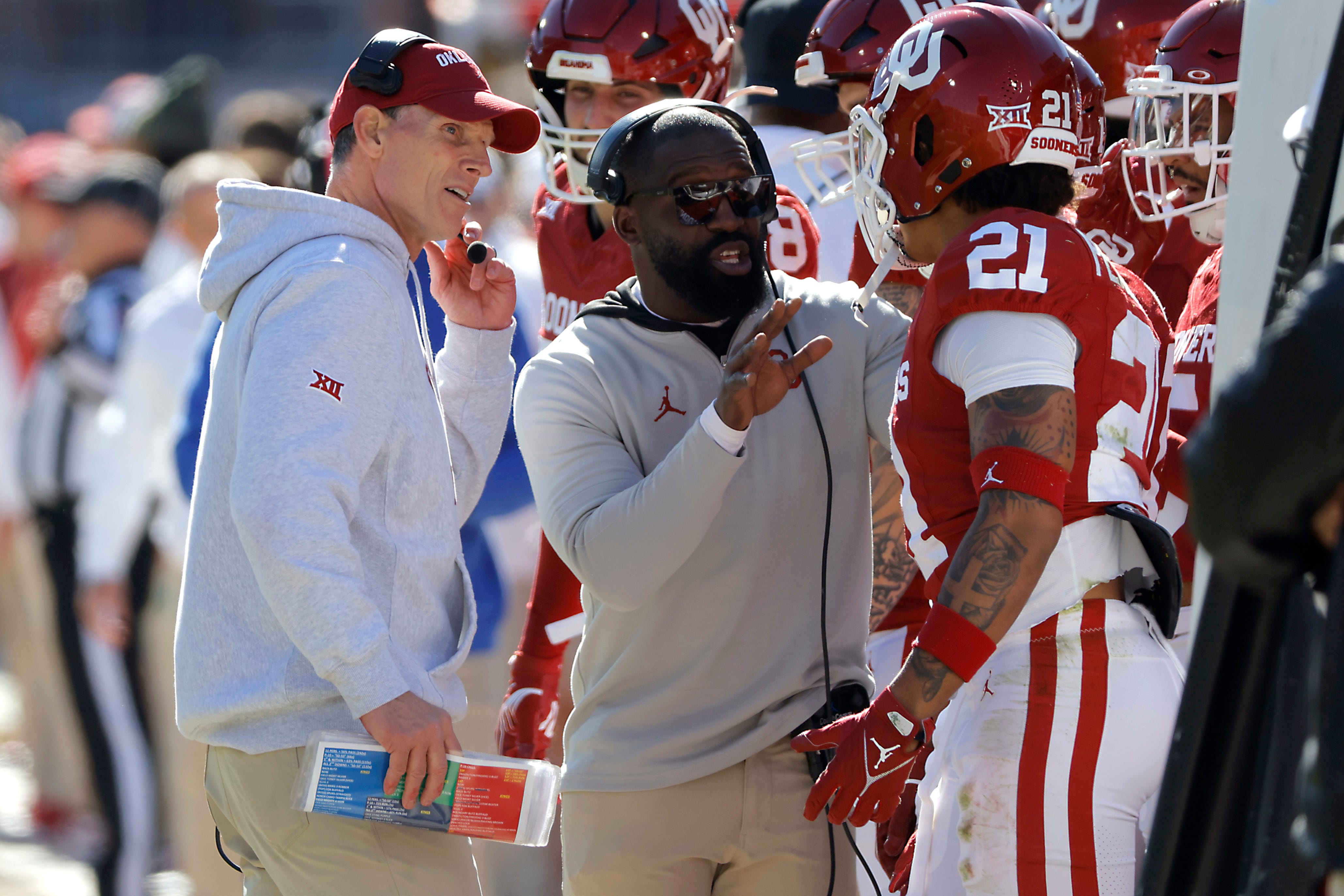Oklahoma coach Brent Venables, left, and Jay Valai, co-defensive coordinator/cornerbacks coach, talk with Oklahoma Sooners defensive back Reggie Pearson (21) during a college football game between the University of Oklahoma Sooners (OU) and the TCU Horned Frogs at Gaylord Family-Oklahoma Memorial Stadium in Norman, Okla., Friday, Nov. 24, 2023. Oklahoma won 69-45.