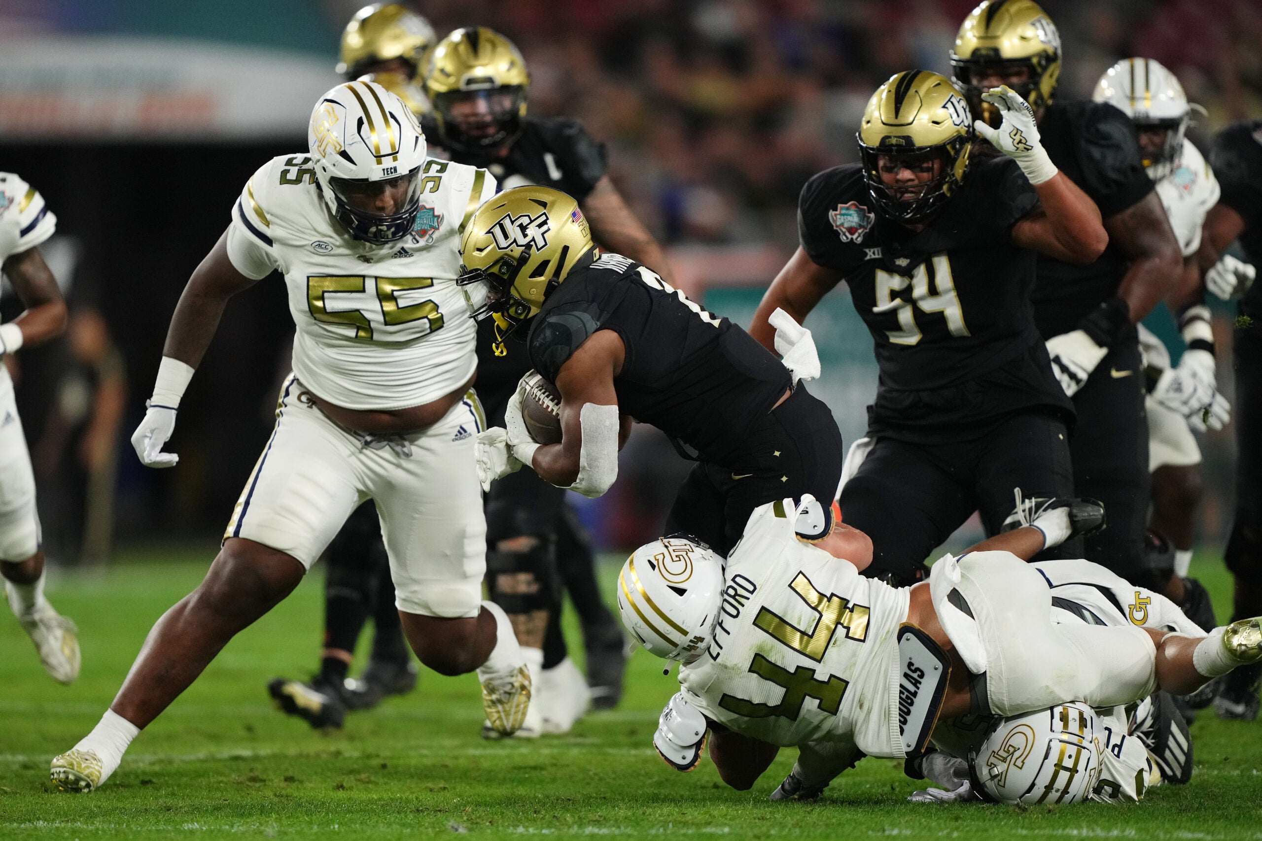Dec 22, 2023; Tampa, FL, USA; Georgia Tech Yellow Jackets linebacker Kyle Efford (44) and Georgia Tech Yellow Jackets defensive lineman Horace Lockett (55) bring down UCF Knights running back RJ Harvey (7) during the first half of the Gasparilla Bowl at Raymond James Stadium. Mandatory Credit: Jasen Vinlove-USA TODAY Sports