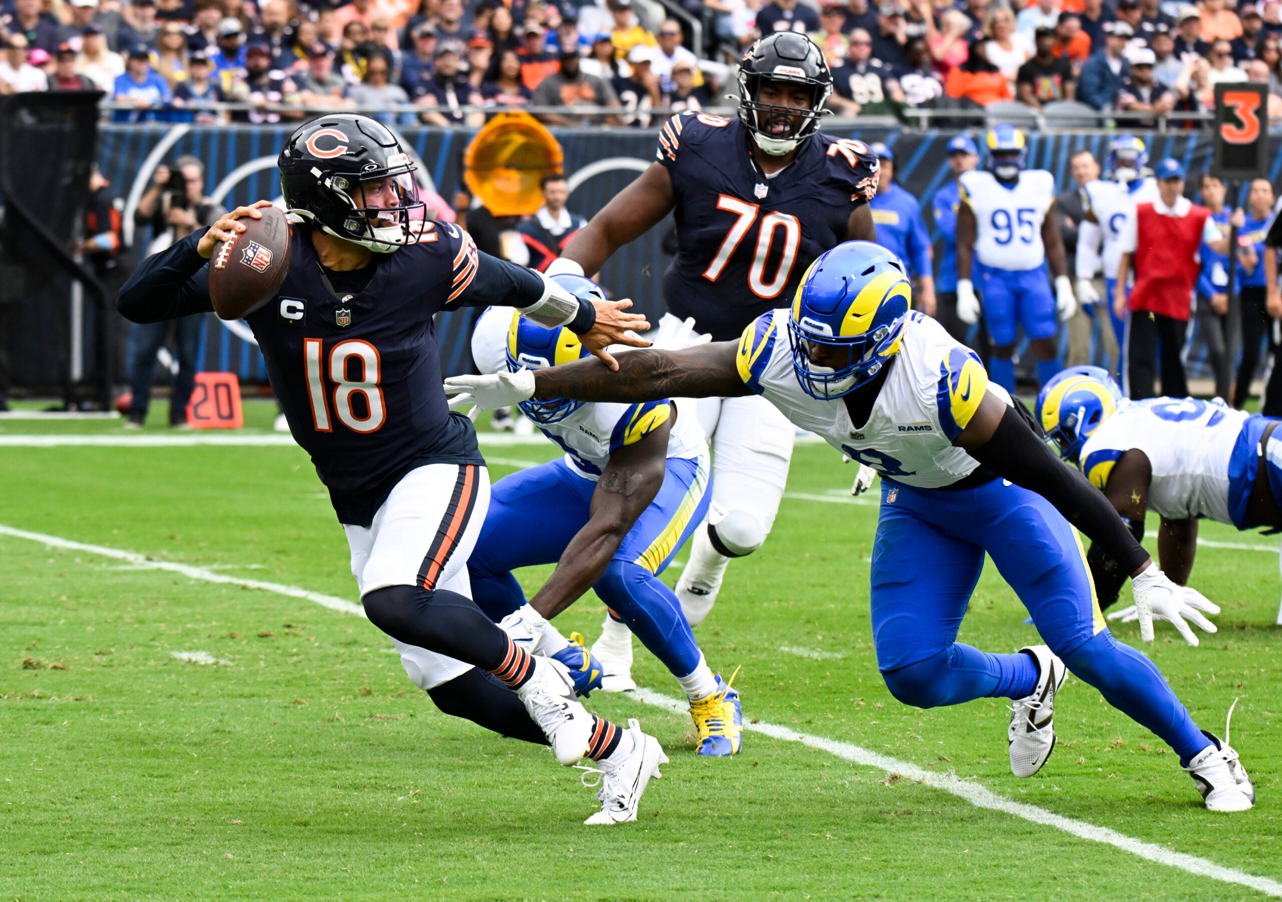 Sep 29, 2024; Chicago, Illinois, USA; Los Angeles Rams linebacker Jared Verse (8) chases Chicago Bears quarterback Caleb Williams (18) during the first half at Soldier Field.