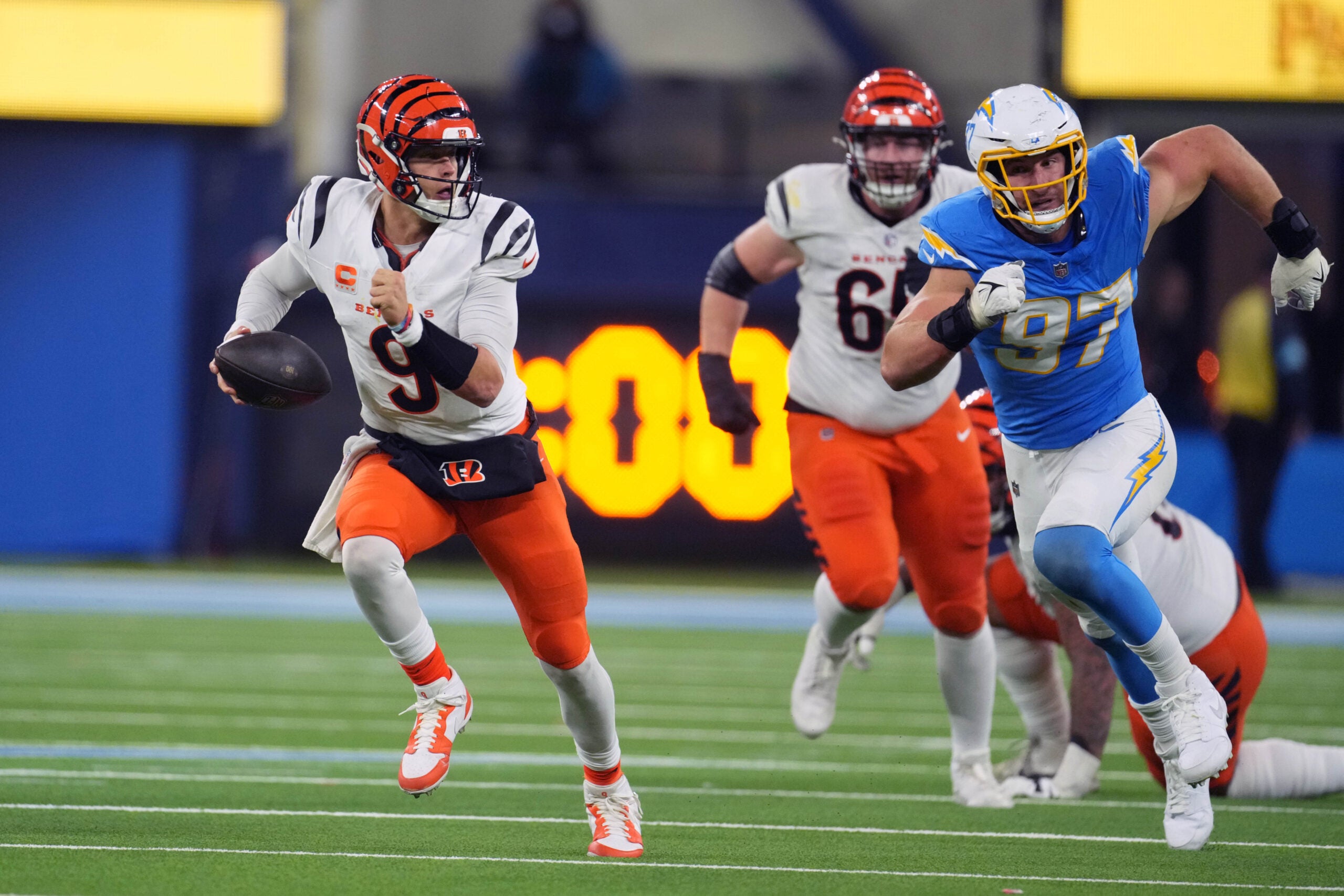 Nov 17, 2024; Inglewood, California, USA; Cincinnati Bengals quarterback Joe Burrow (9) is pursued by Los Angeles Chargers linebacker Joey Bosa (97) in the second half at SoFi Stadium.