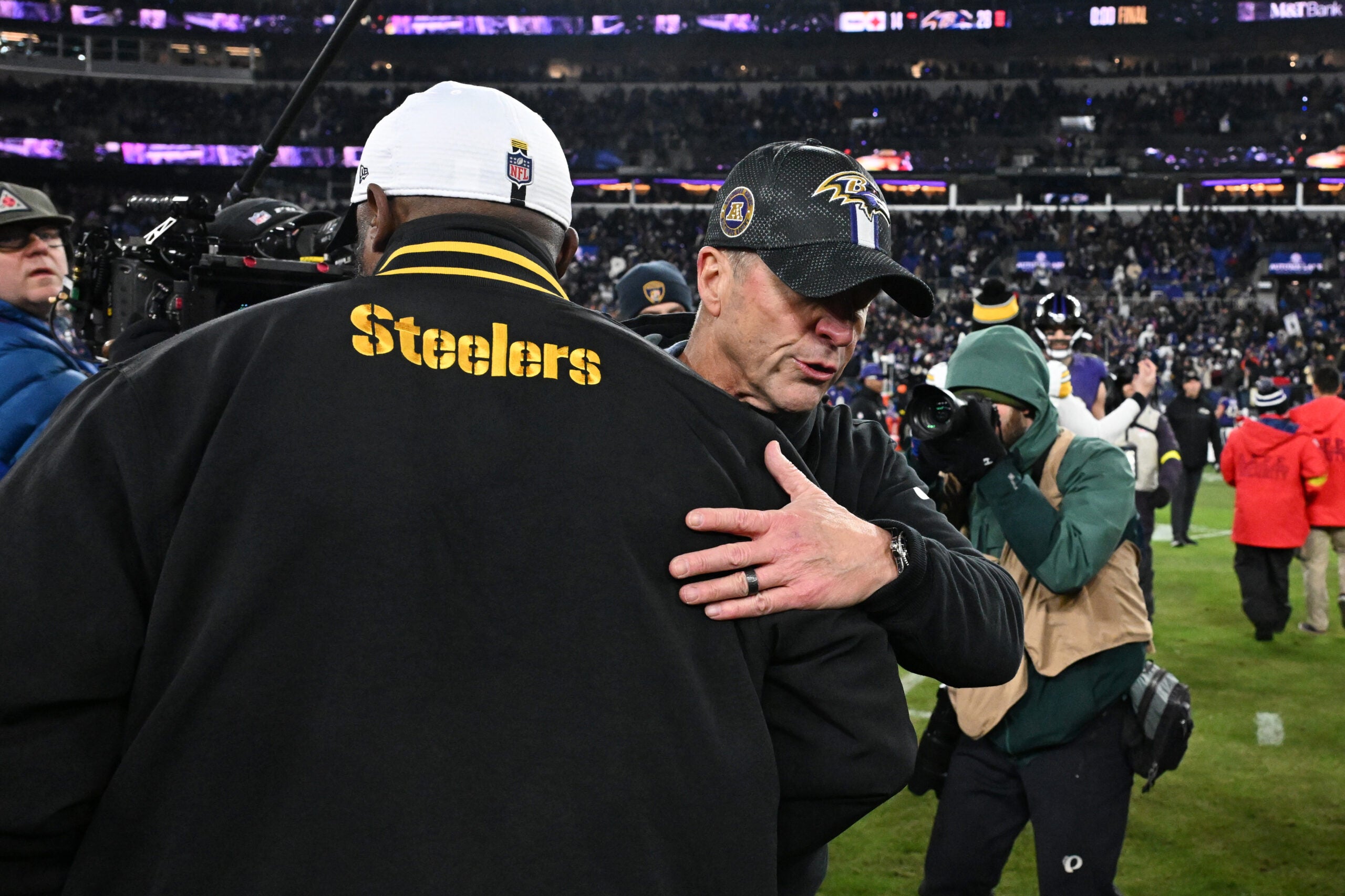 Jan 11, 2025; Baltimore, Maryland, USA; Baltimore Ravens head coach John Harbaugh embraces Pittsburgh Steelers head coach Mike Tomlin after an AFC wild card game at M&T Bank Stadium.