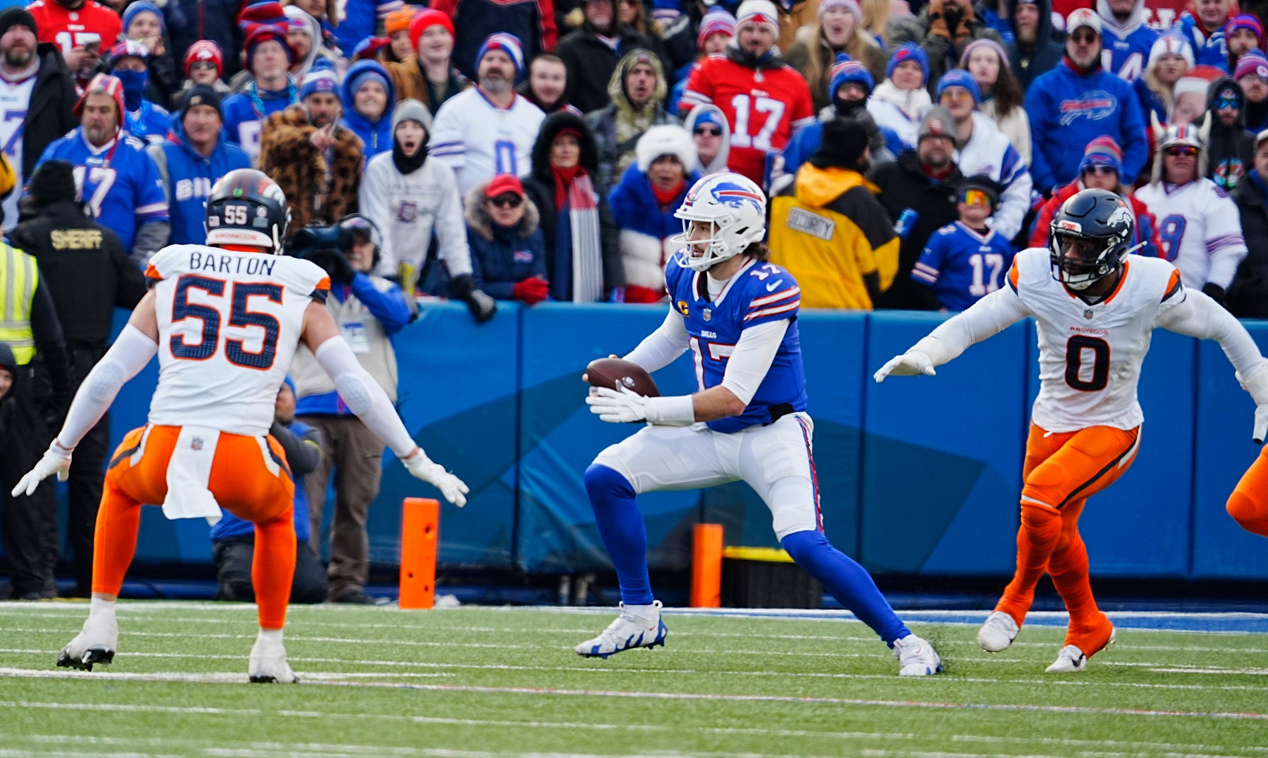 Buffalo Bills quarterback Josh Allen (17) scrambles avoiding Denver Broncos linebacker Cody Barton (55) and Denver Broncos linebacker Jonathon Cooper (0) and funs for a few yards before sliding down during the second half of the Buffalo Bills wild card game against the Denver Broncos at Highmark Stadium in Orchard Park on Jan. 12, 2025.