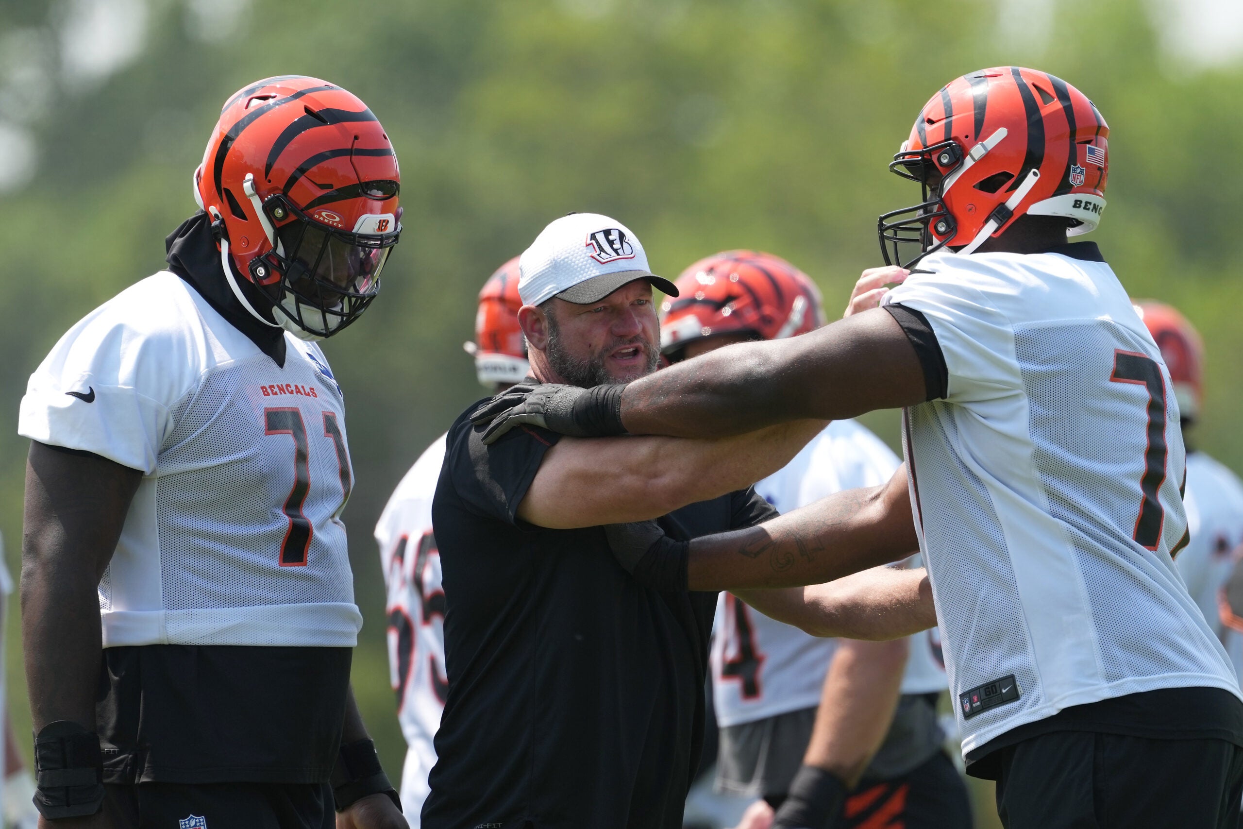 Jun 10, 2025; Cincinnati, OH, USA; Cincinnati Bengals offensive line coach Scott Peters (center) works with offensive tackle Amarius Mims (71) (left) and offensive tackle Caleb Etienne (77) )(right) during practice at Paycor Stadium.