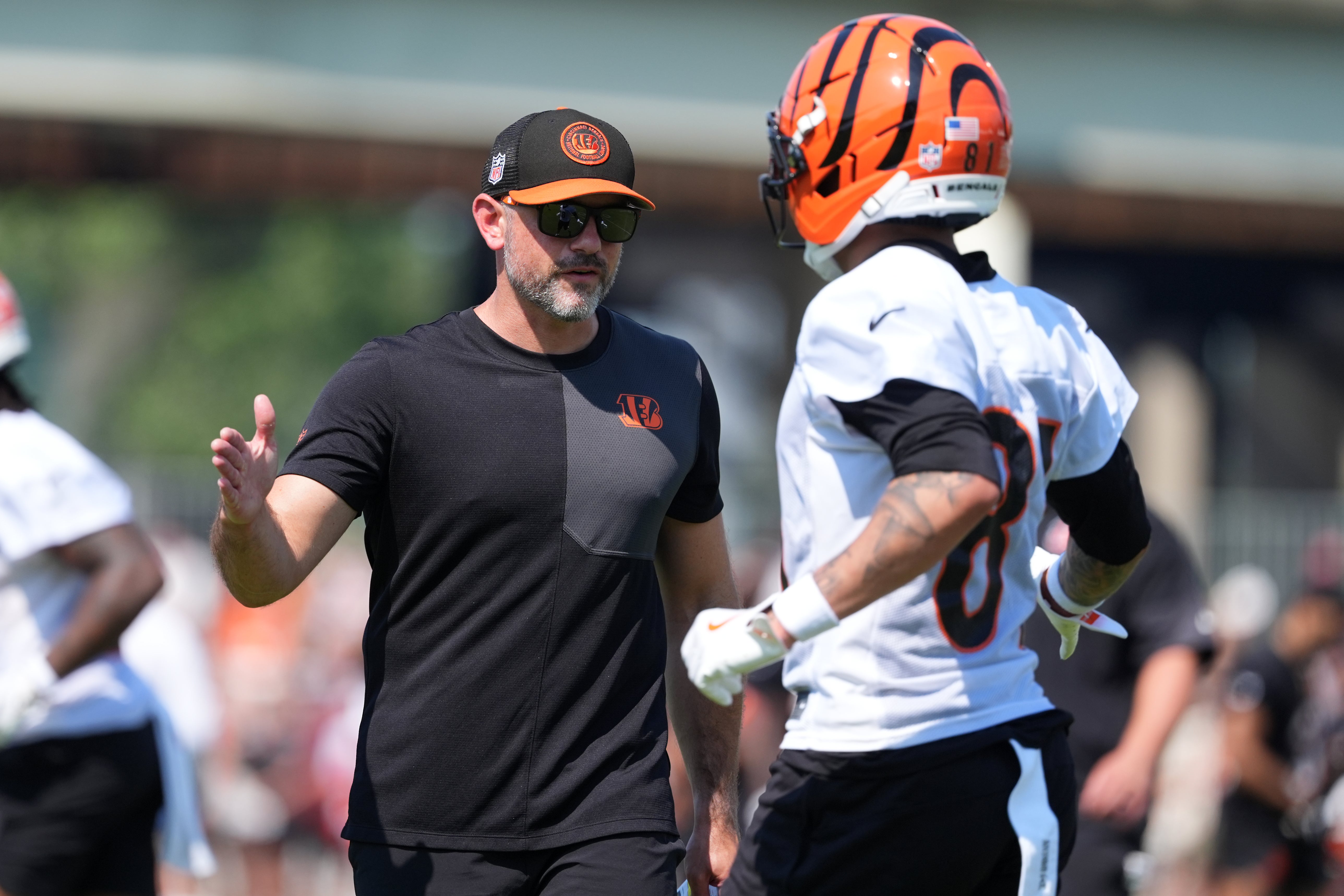 Jul 25, 2025; Cincinnati, OH, USA; Cincinnati Bengals offensive coordinator Dan Pitcher high fives Cincinnati Bengals wide receiver Jermaine Burton (81) after a completed catch during training camp practice.