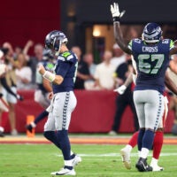 Sep 25, 2025; Glendale, Arizona, USA; Seattle Seahawks quarterback Sam Darnold (14) and offensive tackle Charles Cross (67) celebrate after a touchdown by tight end AJ Barner (88) in the first quarter against the Arizona Cardinals at State Farm Stadium.