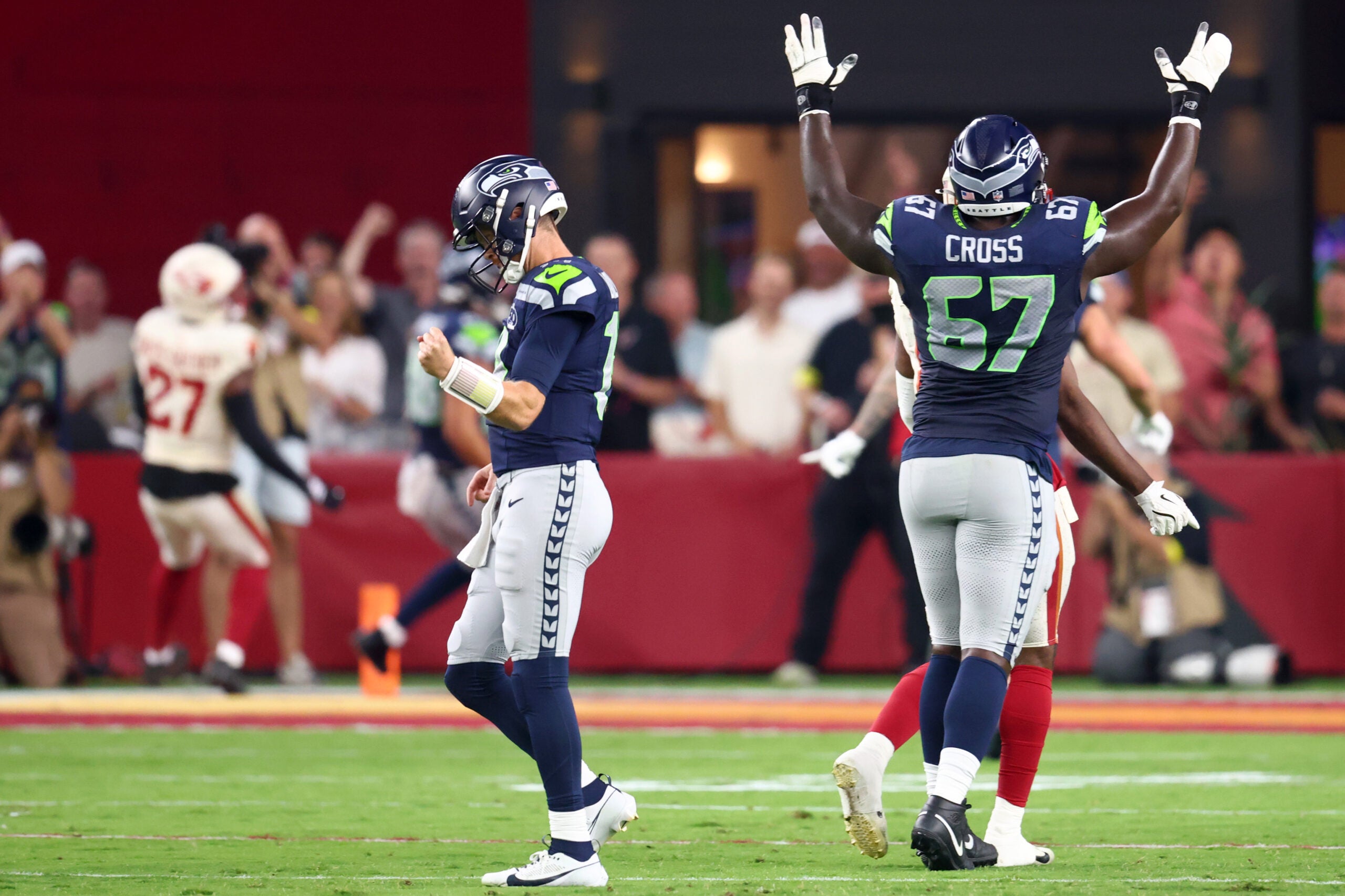 Sep 25, 2025; Glendale, Arizona, USA; Seattle Seahawks quarterback Sam Darnold (14) and offensive tackle Charles Cross (67) celebrate after a touchdown by tight end AJ Barner (88) in the first quarter against the Arizona Cardinals at State Farm Stadium.