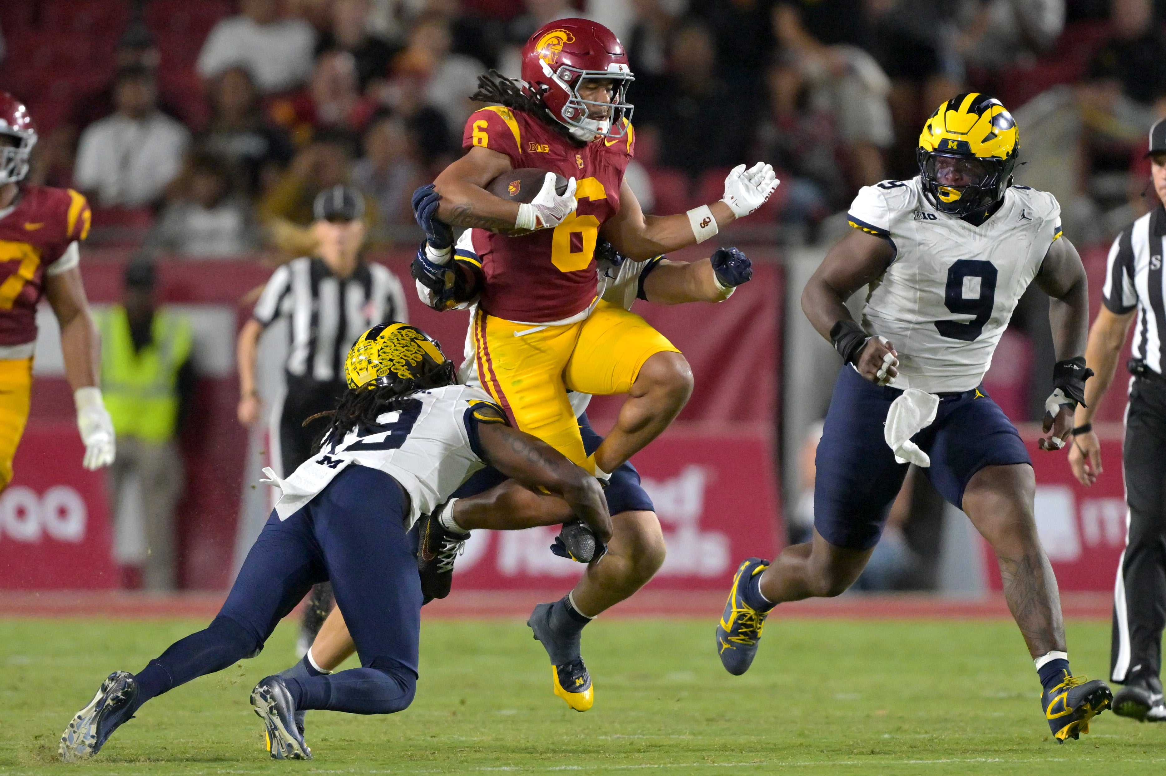 Oct 11, 2025; Los Angeles, California, USA; USC Trojans wide receiver Makai Lemon (6) runs for a first down before he is stopped by Michigan Wolverines linebacker Jimmy Rolder (30), defensive back Rod Moore (19) and defensive end Cameron Brandt (9) in the second half at United Airlines Field at the Los Angeles Memorial Coliseum.