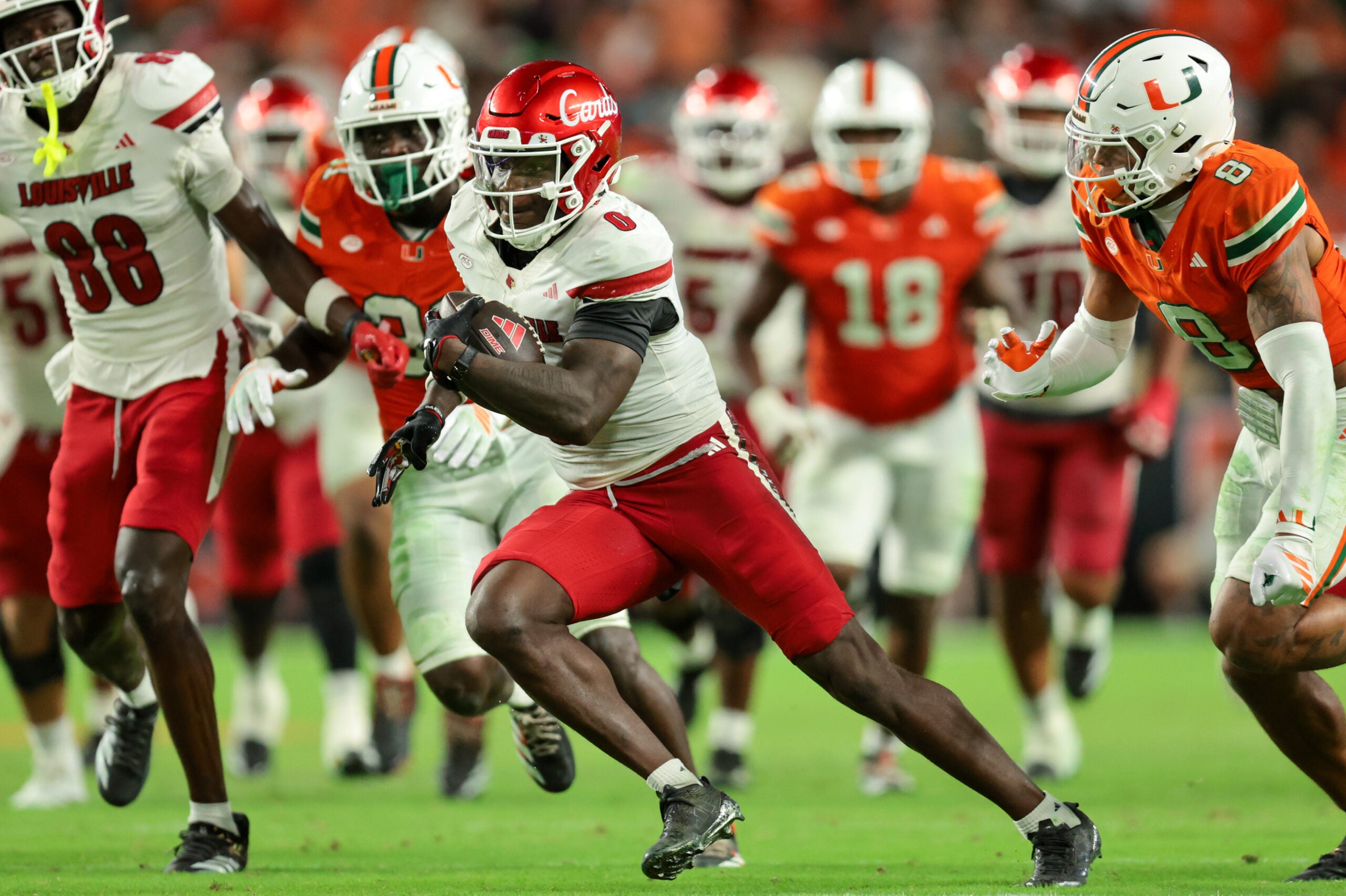 Oct 17, 2025; Miami Gardens, Florida, USA; Louisville Cardinals wide receiver Chris Bell (0) carries the football for a touchdown against the Miami Hurricanes during the fourth quarter at Hard Rock Stadium.
