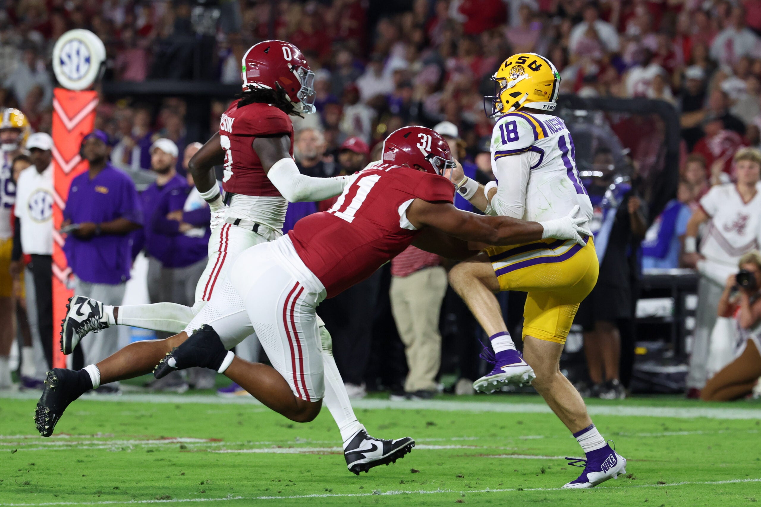 Nov 8, 2025; Tuscaloosa, Alabama, USA; Louisiana State Tigers quarterback Garrett Nussmeier (18) under pressure from Alabama Crimson Tide linebacker Deontae Lawson (0) and defensive lineman Keon Keeley (31) during the second quarter of the game at Saban Field at Bryant-Denny Stadium. Mandatory Credit: David Leong-Imagn Images