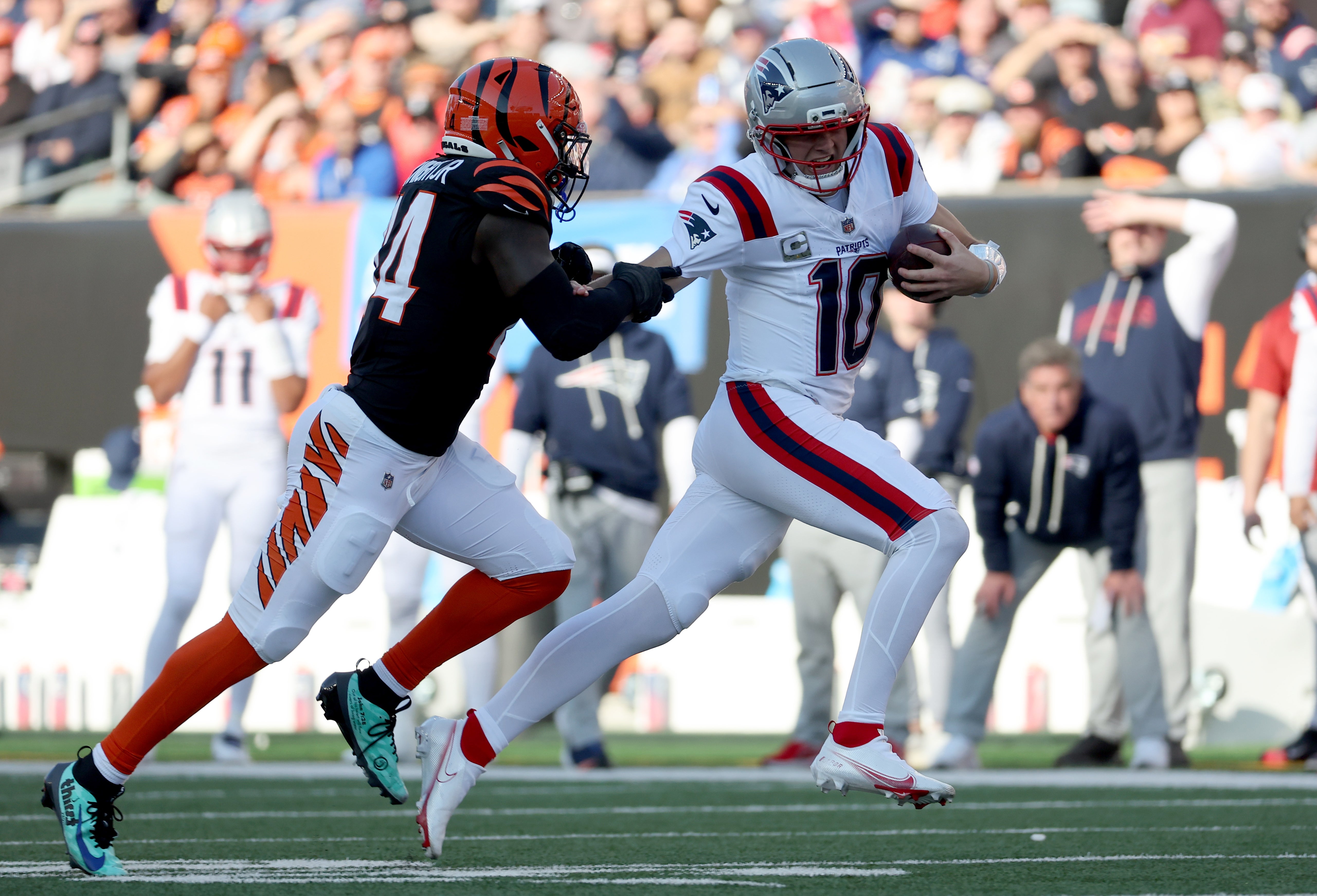 Nov 23, 2025; Cincinnati, Ohio, USA; New England Patriots quarterback Drake Maye (10) runs against Cincinnati Bengals linebacker Demetrius Knight Jr. (44) during the first half at Paycor Stadium.