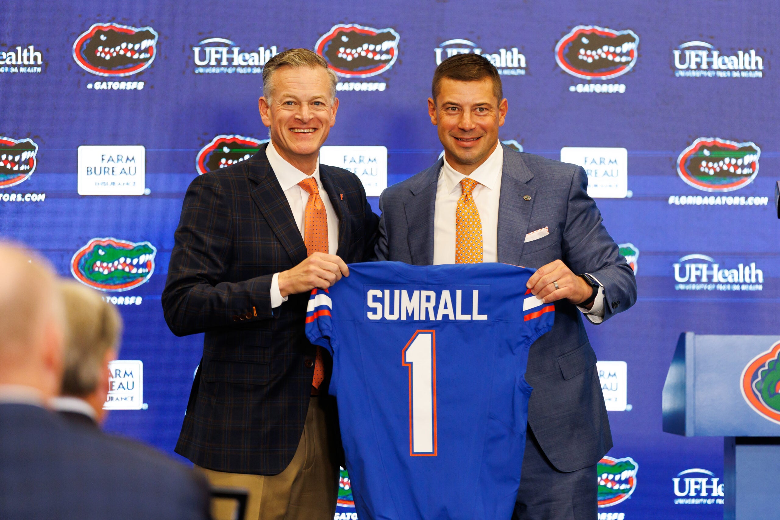 Dec 1, 2025; Gainesville, FL, USA; Florida Gators athletic director Scott Stricklin and Florida Gators head coach Jon Sumrall poses with a Florida Gators jersey during the press conference at the Heavener Football Training Center at the University of Florida.