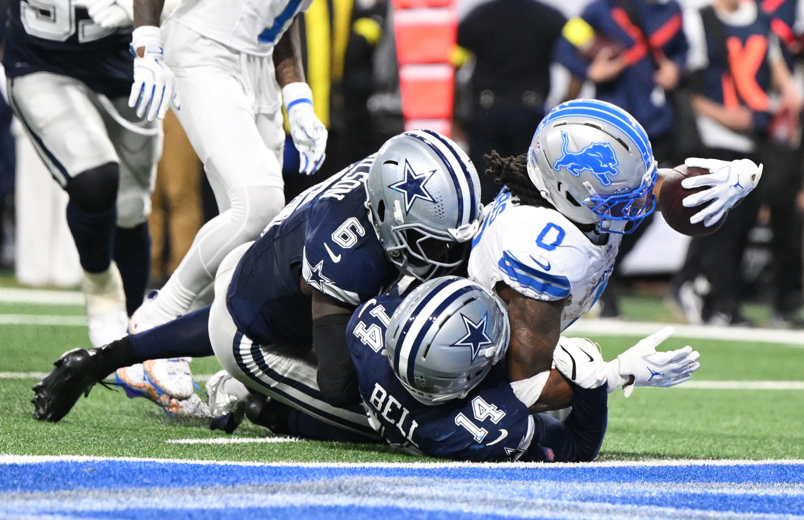 Dec 4, 2025; Detroit, Michigan, USA; Detroit Lions running back Jahmyr Gibbs (0) scores a touchdown against Dallas Cowboys safety Markquese Bell (14) and safety Donovan Wilson (6) during the second half at Ford Field.