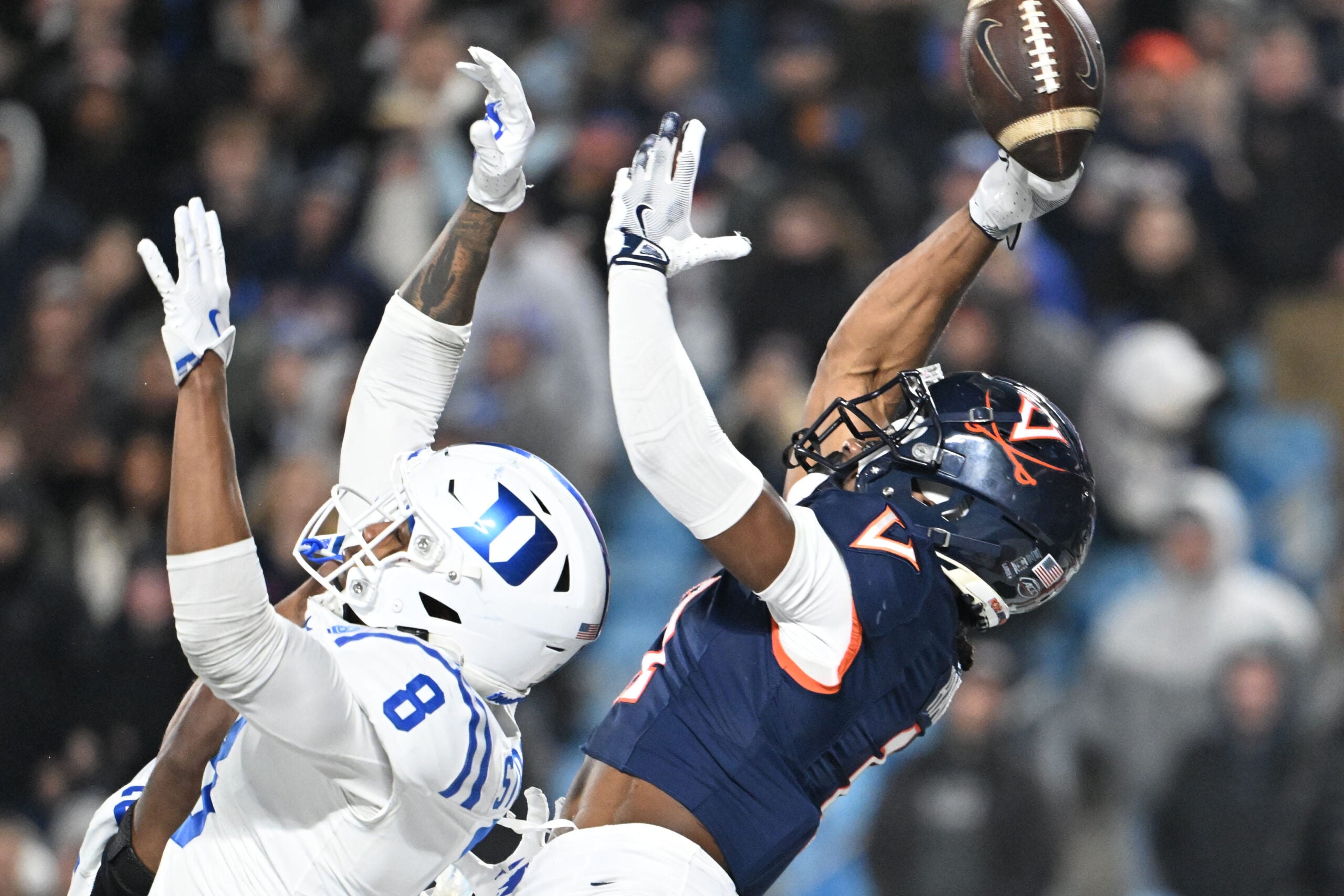 Dec 6, 2025; Charlotte, NC, USA; Virginia Cavaliers wide receiver Trell Harris (11) attempts to catch the ball in the end zone as Duke Blue Devils cornerback Landan Callahan (21) and safety Dashawn Stone (8) defend in the fourth quarter during the ACC Championship game at Bank of America Stadium.
