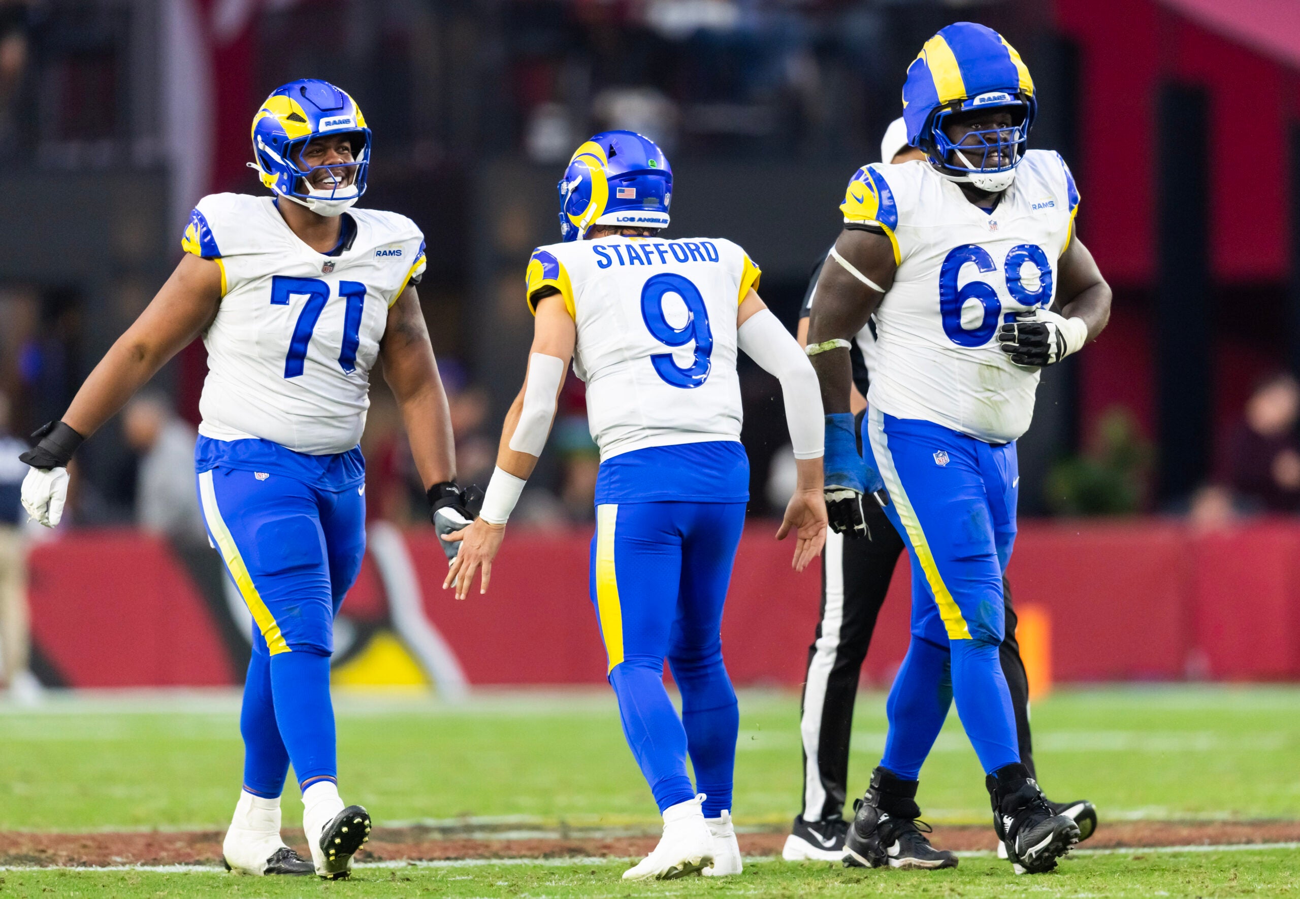 Dec 7, 2025; Glendale, Arizona, USA; Los Angeles Rams quarterback Matthew Stafford (9) celebrates a touchdown with offensive lineman Warren McClendon Jr. (71) and Kevin Dotson (69) against the Arizona Cardinals at State Farm Stadium.
