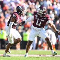 Dec 20, 2025; College Station, TX, USA; Texas A&M Aggies linebacker Daymion Sanford (27) reacts with defensive tackle Tyler Onyedim (11) after recovering a fumble against the Miami Hurricanes during the second half of the first round game of the CFP National Playoff at Kyle Field.