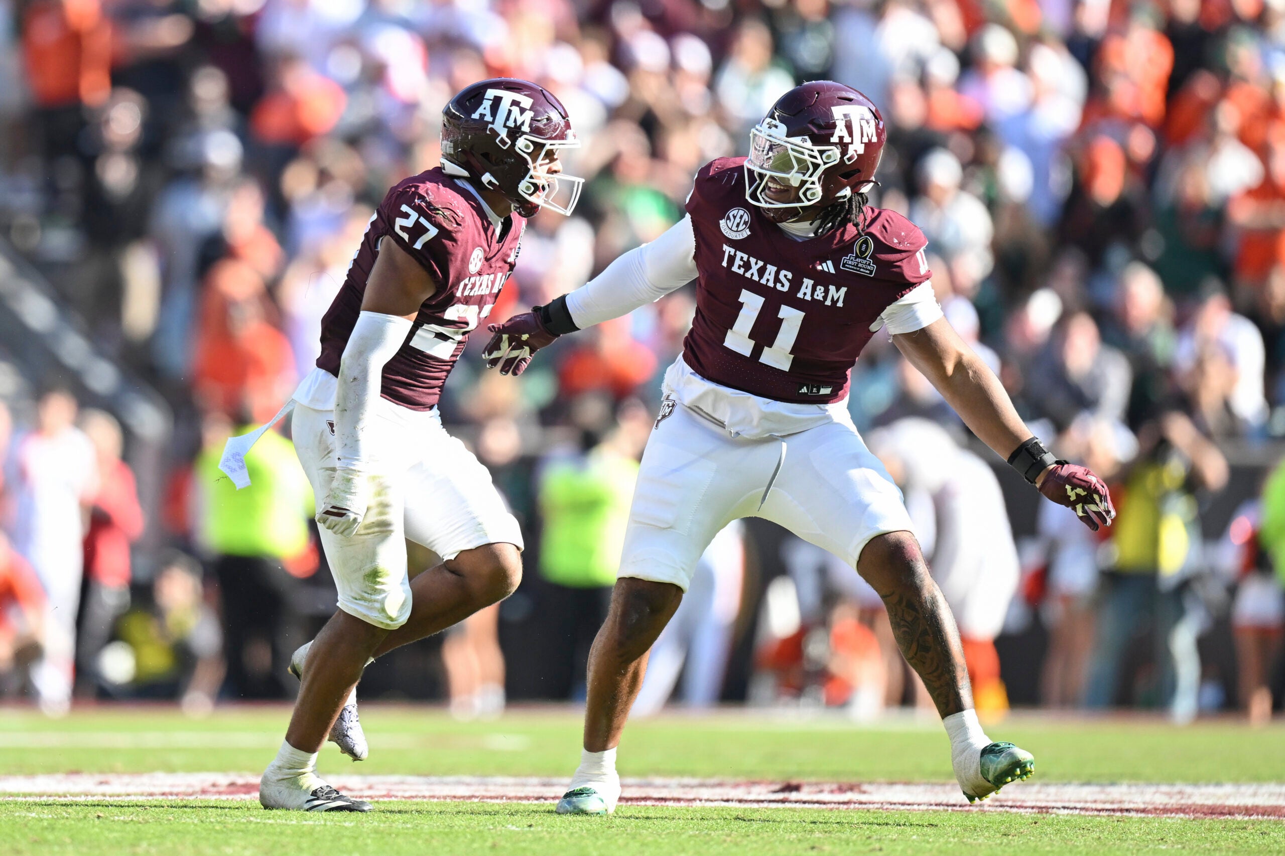 Dec 20, 2025; College Station, TX, USA; Texas A&M Aggies linebacker Daymion Sanford (27) reacts with defensive tackle Tyler Onyedim (11) after recovering a fumble against the Miami Hurricanes during the second half of the first round game of the CFP National Playoff at Kyle Field.