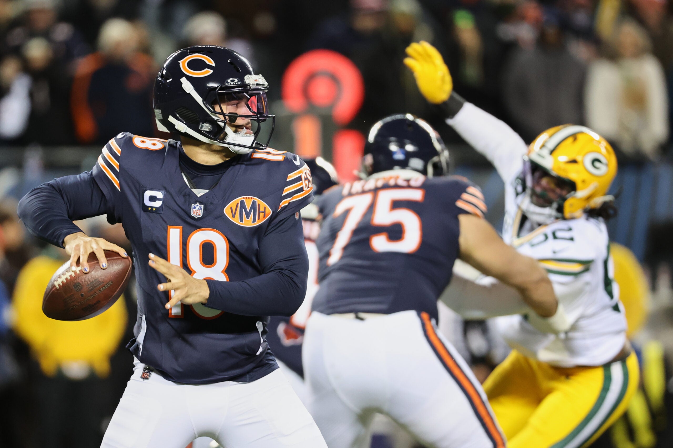Dec 20, 2025; Chicago, Illinois, USA; Chicago Bears quarterback Caleb Williams (18) prepares to throw a pass and offensive tackle Ozzy Trapilo (75) blocks against Green Bay Packers defensive end Rashan Gary (52) during the first quarter at Soldier Field.
