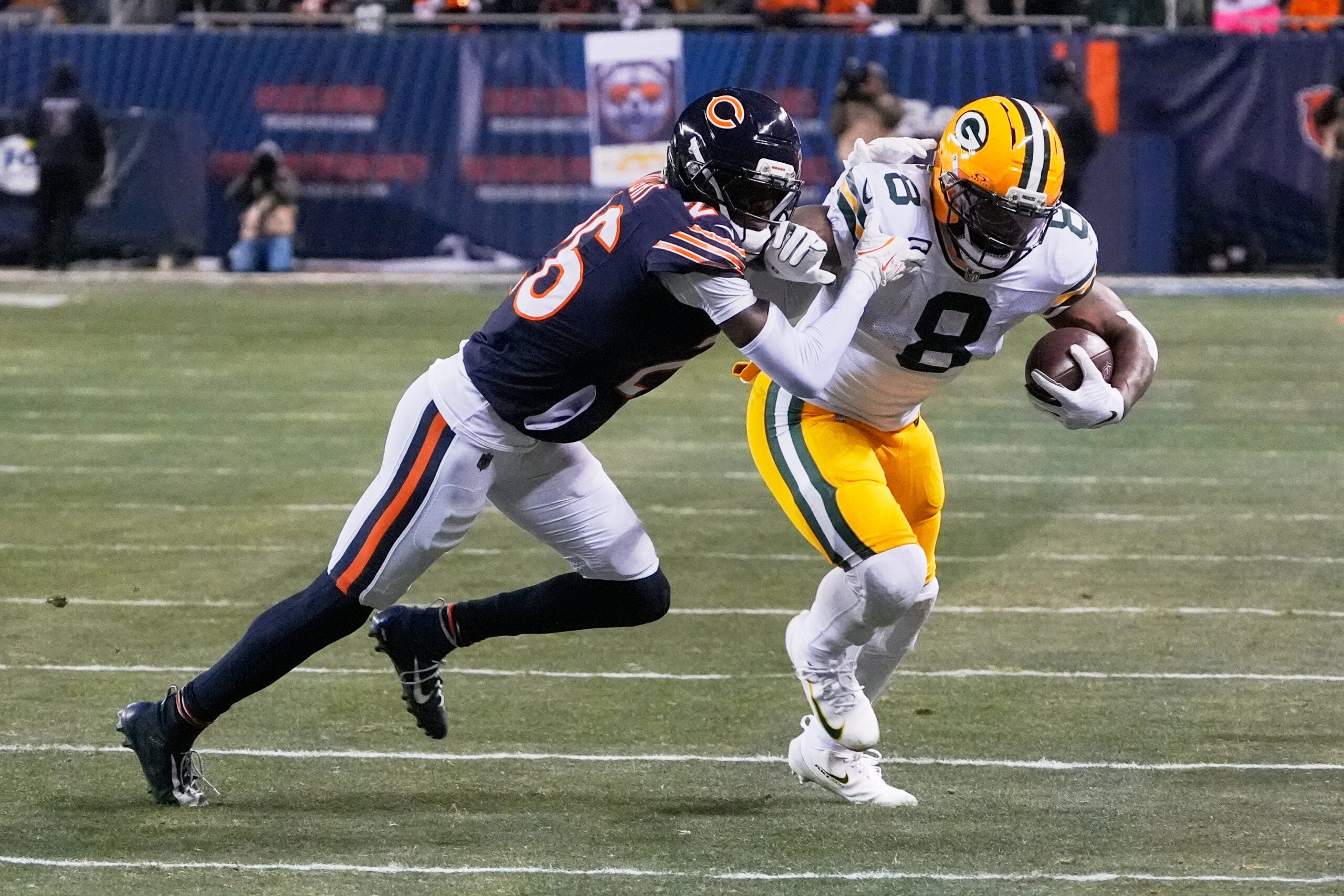 Dec 20, 2025; Chicago, Illinois, USA; Green Bay Packers running back Josh Jacobs (8) runs with the ball against Chicago Bears cornerback Nahshon Wright (26) during the first quarter at Soldier Field.
