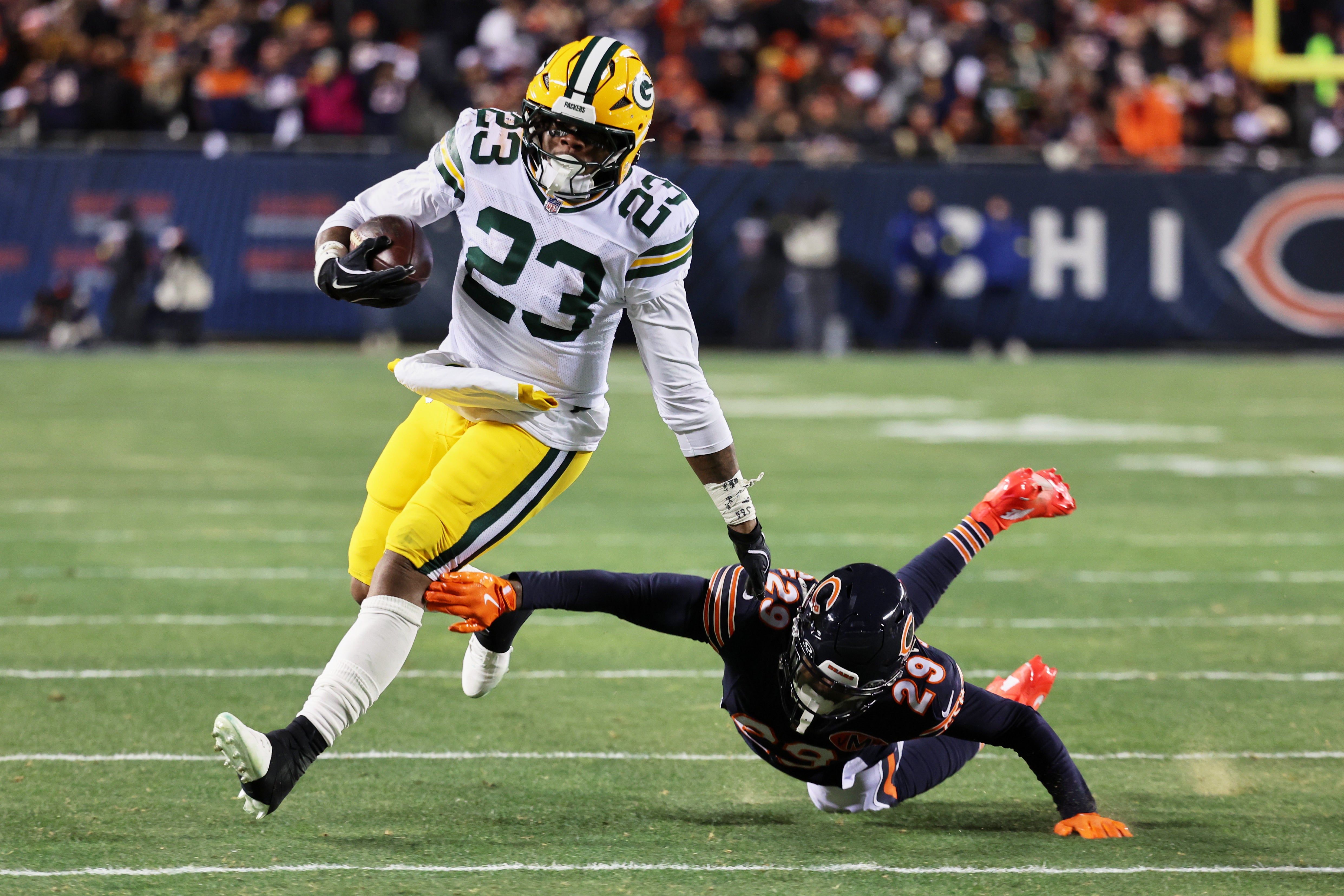 Dec 20, 2025; Chicago, Illinois, USA; Green Bay Packers running back Emanuel Wilson (23) runs with the ball against Chicago Bears cornerback Tyrique Stevenson (29) during the second quarter at Soldier Field.