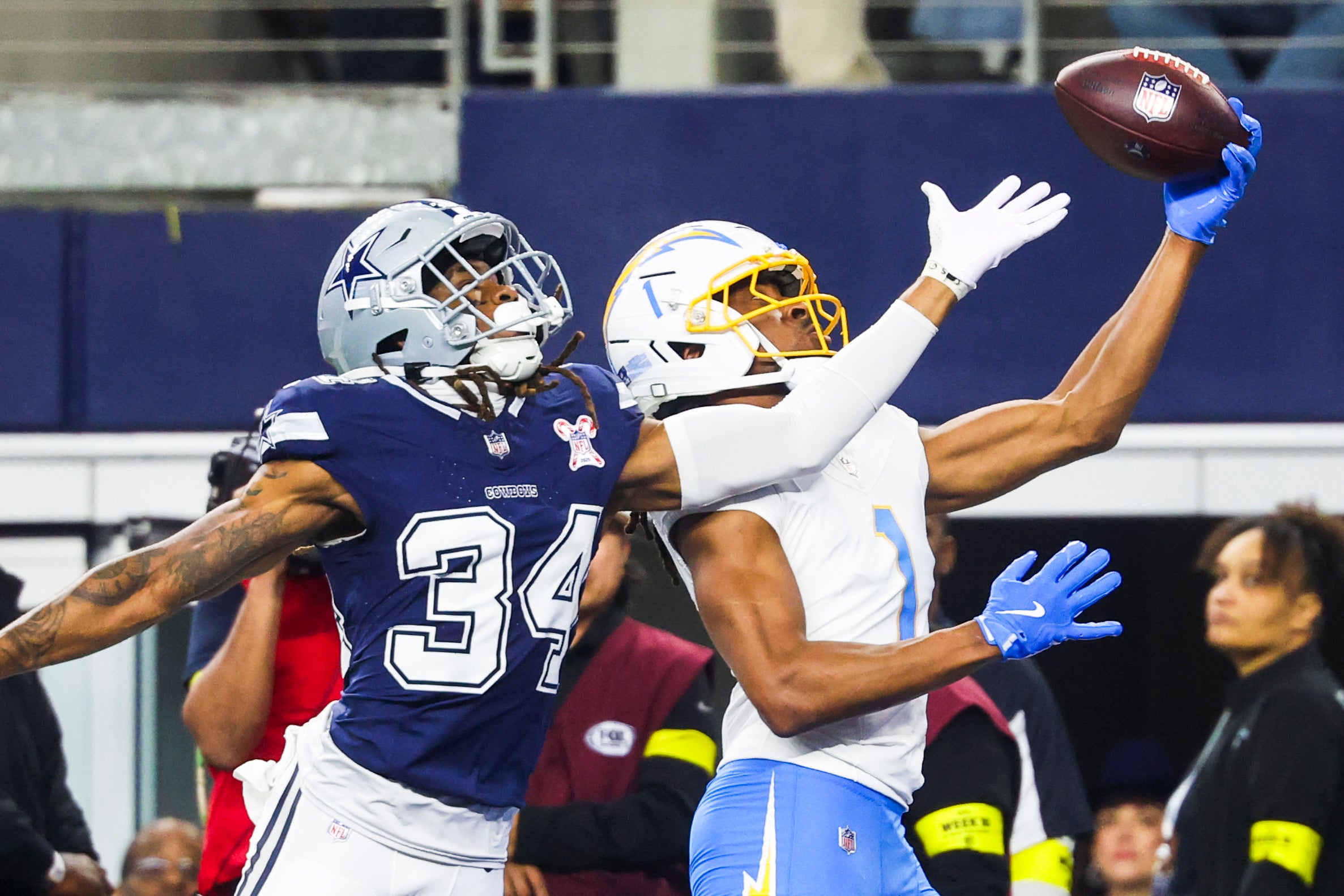 Dec 21, 2025; Arlington, Texas, USA; Los Angeles Chargers wide receiver Quentin Johnston (1) catches a touchdown pass against Dallas Cowboys cornerback Shavon Revel Jr. (34) during the first quarter at AT&T Stadium.