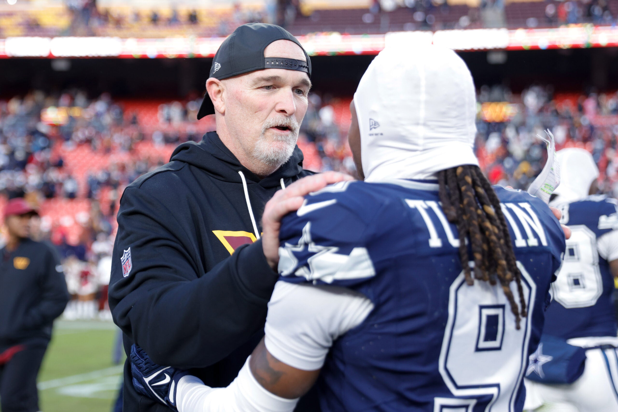 Dec 25, 2025; Landover, Maryland, USA; Washington Commanders head coach Dan Quinn speaks to Dallas Cowboys wide receiver KaVontae Turpin (9) after the game at Northwest Stadium.