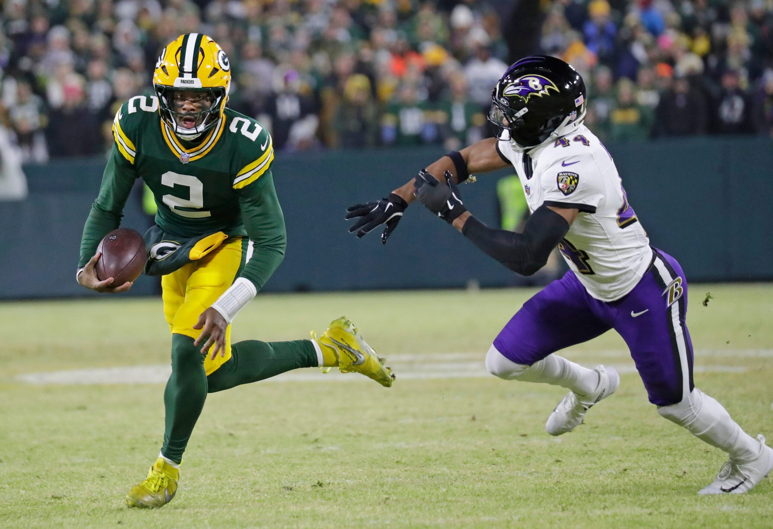 Dec 27, 2025; Green Bay, Wisconsin, USA; Green Bay Packers quarterback Malik Willis (2) breaks away from Baltimore Ravens cornerback Marlon Humphrey (44) to score a touchdown in the second quarter at Lambeau Field in Green Bay, Wisconsin.