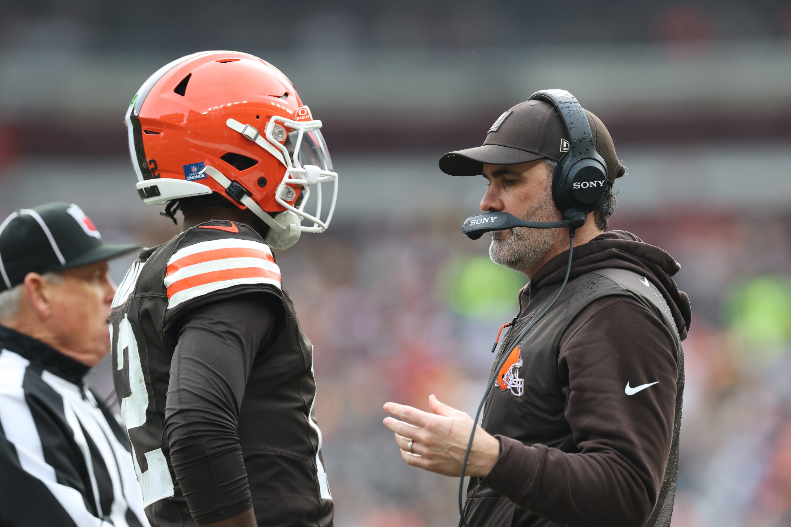 Dec 28, 2025; Cleveland, Ohio, USA; Cleveland Browns head coach Kevin Stefanski speaks with quarterback Shedeur Sanders (12) during a time out in the second quarter against the Pittsburgh Steelers at Huntington Bank Field. Mandatory Credit: Scott Galvin-Imagn Images