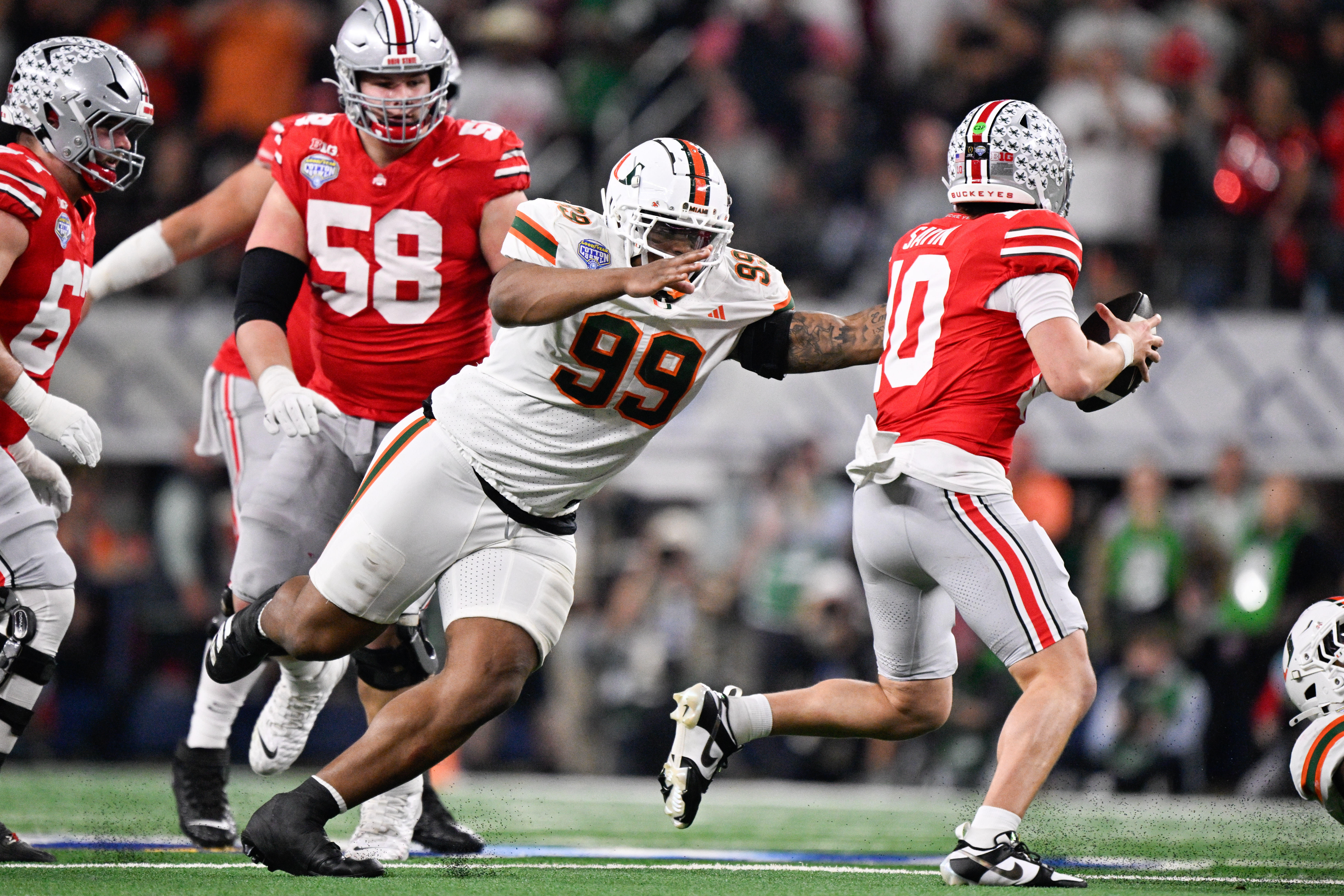 Dec 31, 2025; Arlington, TX, USA; Miami Hurricanes defensive line Ahmad Moten Sr. (99) attempts to sack Ohio State Buckeyes quarterback Julian Sayin (10) in the second quarter during the 2025 Cotton Bowl and quarterfinal game of the College Football Playoff at AT&T Stadium.