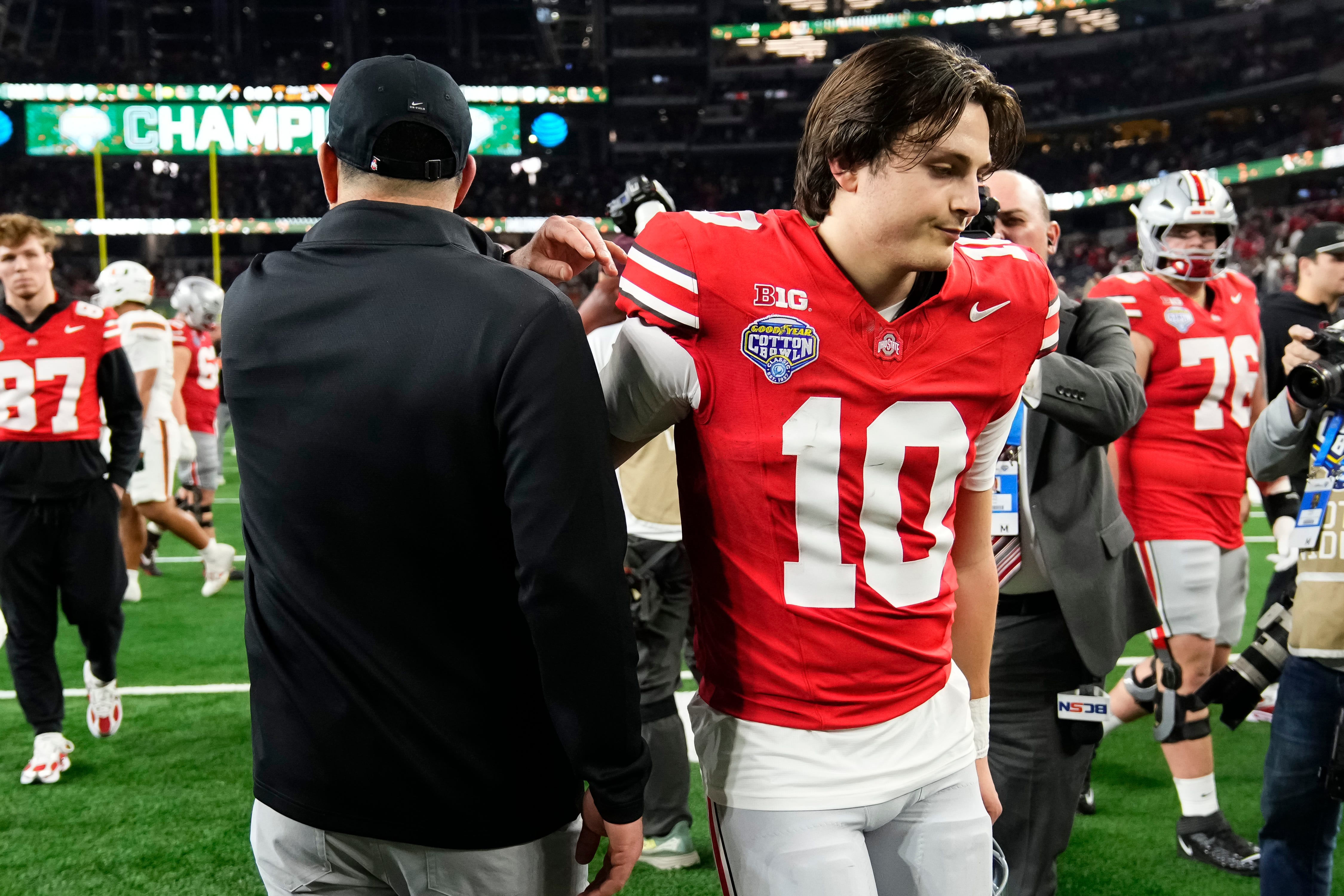 Ohio State Buckeyes quarterback Julian Sayin (10) hugs head coach Ryan Day following the Cotton Bowl at AT&T Stadium in Arlington, Texas for the College Football Playoff quarterfinal game on Dec. 31, 2025. Ohio State lost 24-14.