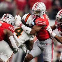 Ohio State Buckeyes defensive back Caleb Downs (2) and defensive end Eddrick Houston (96) tackle Miami Hurricanes running back Mark Fletcher Jr. (4) during the Cotton Bowl at AT&T Stadium in Arlington, Texas for the College Football Playoff quarterfinal game on Dec. 31, 2025. Ohio State lost 24-14.