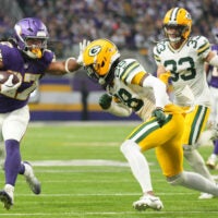 Jan 4, 2026; Minneapolis, Minnesota, USA; Minnesota Vikings running back Jordan Mason (27) runs the ball against Green Bay Packers cornerback Trevon Diggs (28) during the second quarter at U.S. Bank Stadium.