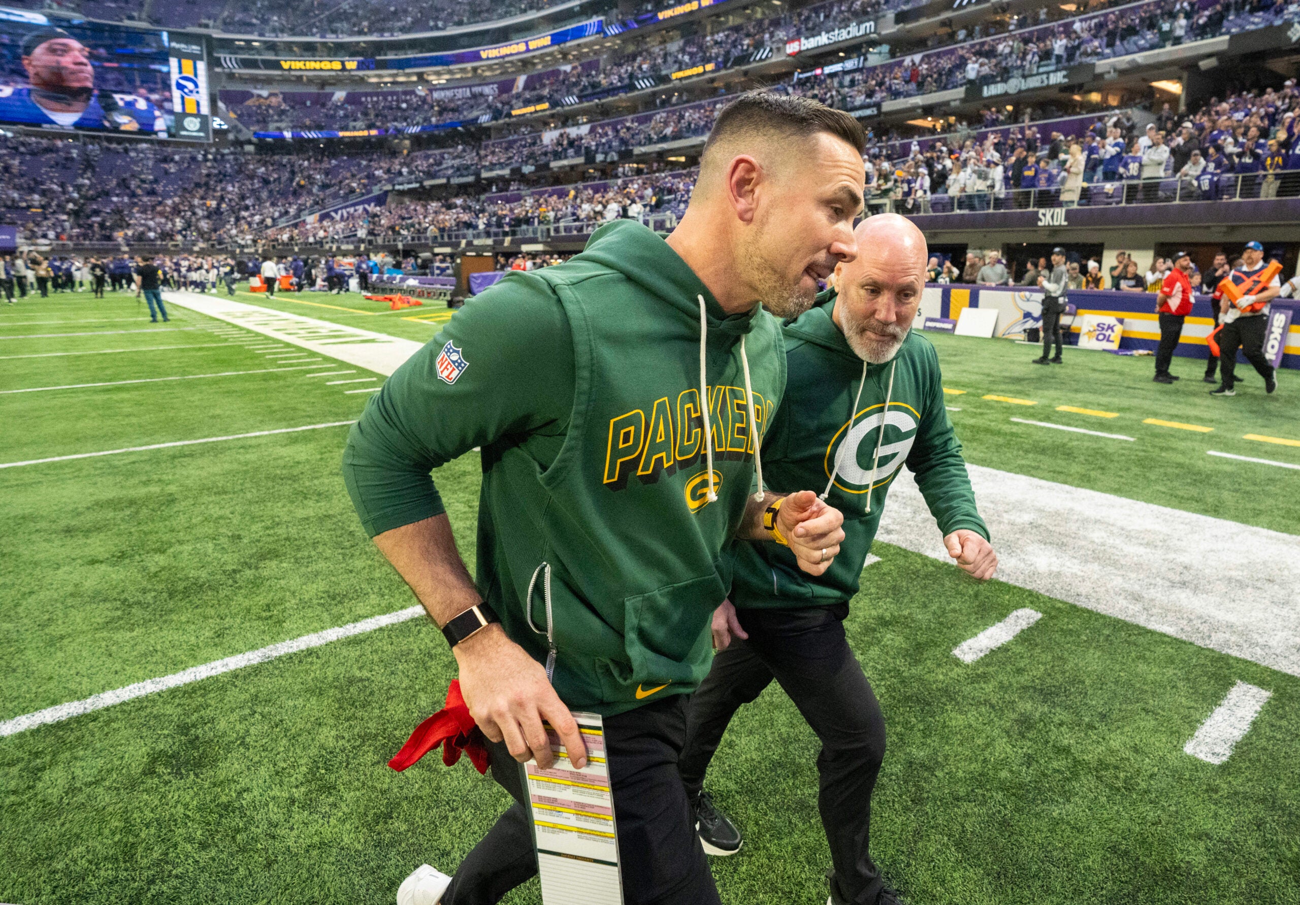 Jan 4, 2026; Minneapolis, Minnesota, USA; Green Bay Packers head coach Matt Lafleur, left, jogs off the field after their game against the Minnesota Vikings at U.S. Bank Stadium.