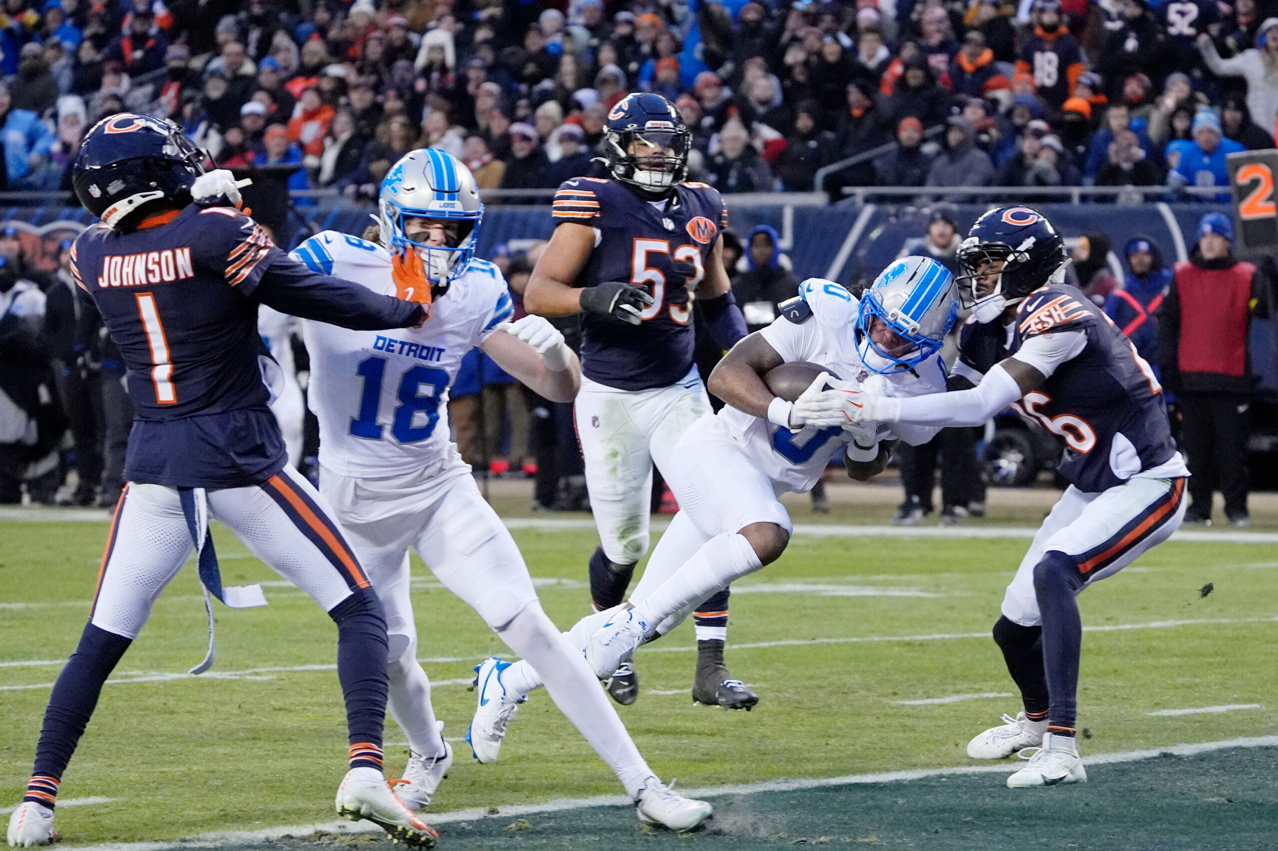 Jan 4, 2026; Chicago, Illinois, USA; Detroit Lions running back Jahmyr Gibbs (0) scores a touchdown against Chicago Bears cornerback Nahshon Wright (26) during the first half at Soldier Field.