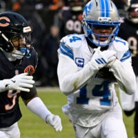 Jan 4, 2026; Chicago, Illinois, USA; Detroit Lions wide receiver Amon-Ra St. Brown (14) runs with the ball against Chicago Bears safety Jaquan Brisker (9) during the first half at Soldier Field.