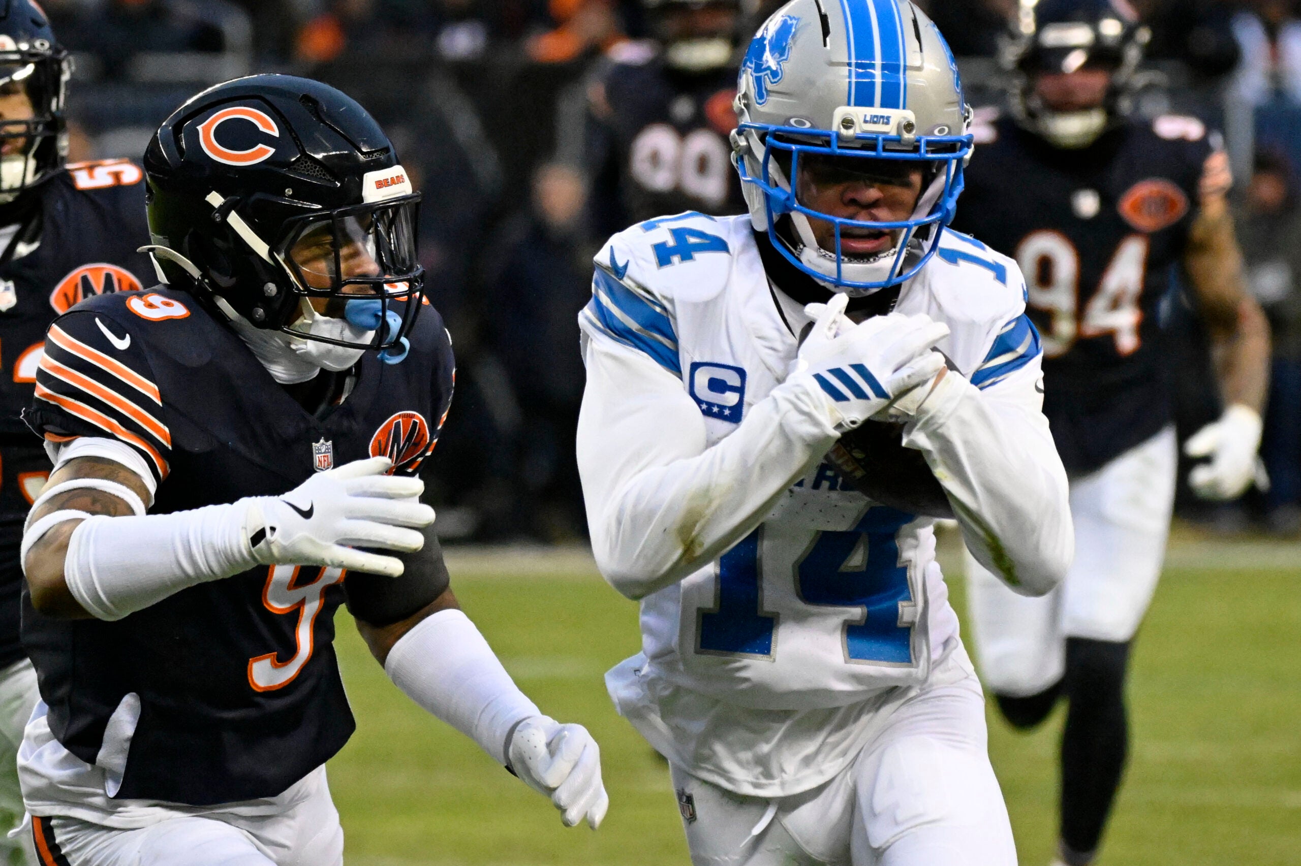 Jan 4, 2026; Chicago, Illinois, USA; Detroit Lions wide receiver Amon-Ra St. Brown (14) runs with the ball against Chicago Bears safety Jaquan Brisker (9) during the first half at Soldier Field.