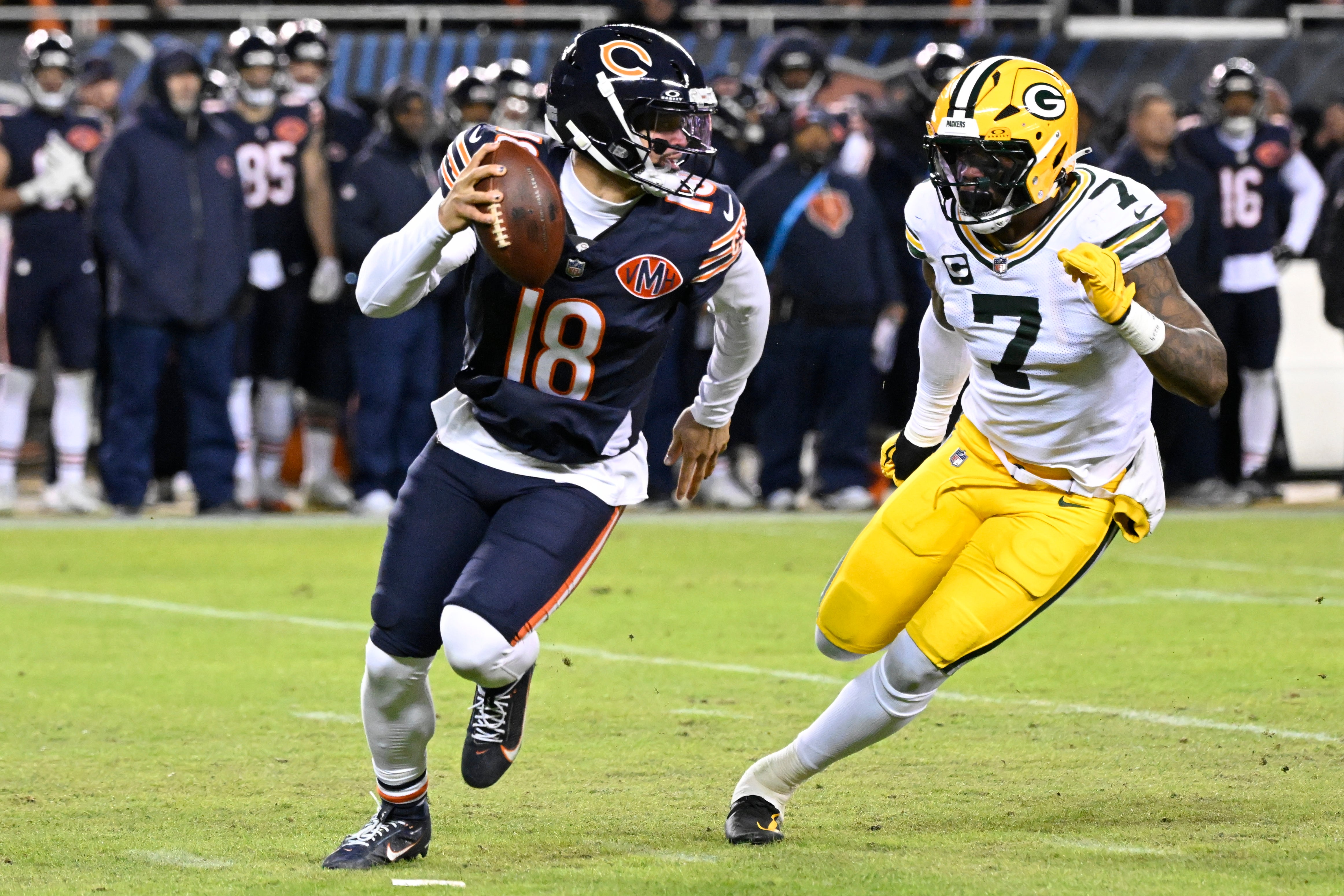 Jan 10, 2026; Chicago, IL, USA; Chicago Bears quarterback Caleb Williams (18) rolls out as Green Bay Packers linebacker Quay Walker (7) applies the pressure during the first half of an NFC Wild Card Round game at Soldier Field.