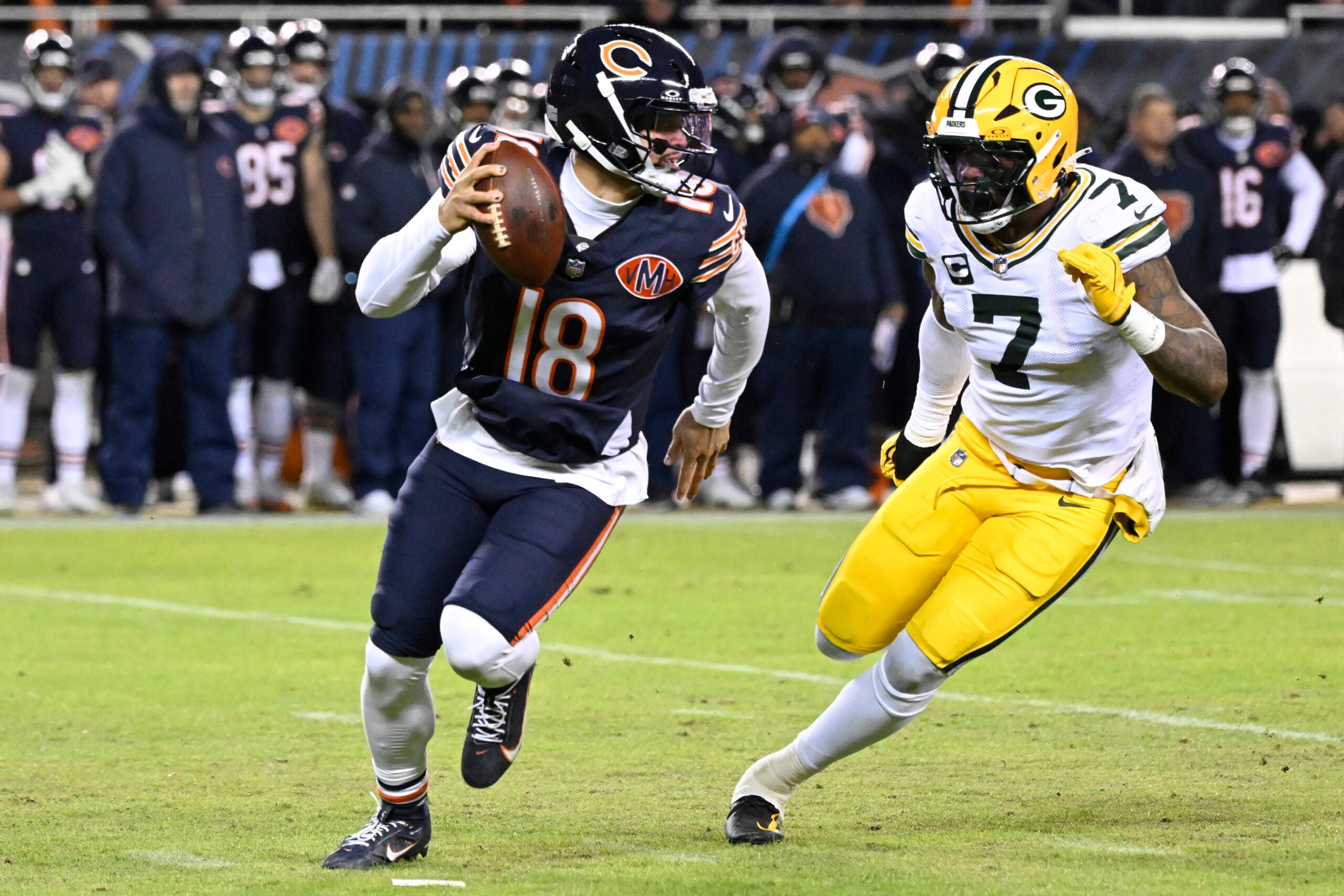 Jan 10, 2026; Chicago, IL, USA; Chicago Bears quarterback Caleb Williams (18) rolls out as Green Bay Packers linebacker Quay Walker (7) applies the pressure during the first half of an NFC Wild Card Round game at Soldier Field.