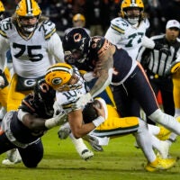 Jan 10, 2026; Chicago, IL, USA; Green Bay Packers quarterback Jordan Love (10) is sacked by Chicago Bears defensive end Austin Booker (94) during the first half of an NFC Wild Card Round game at Soldier Field.