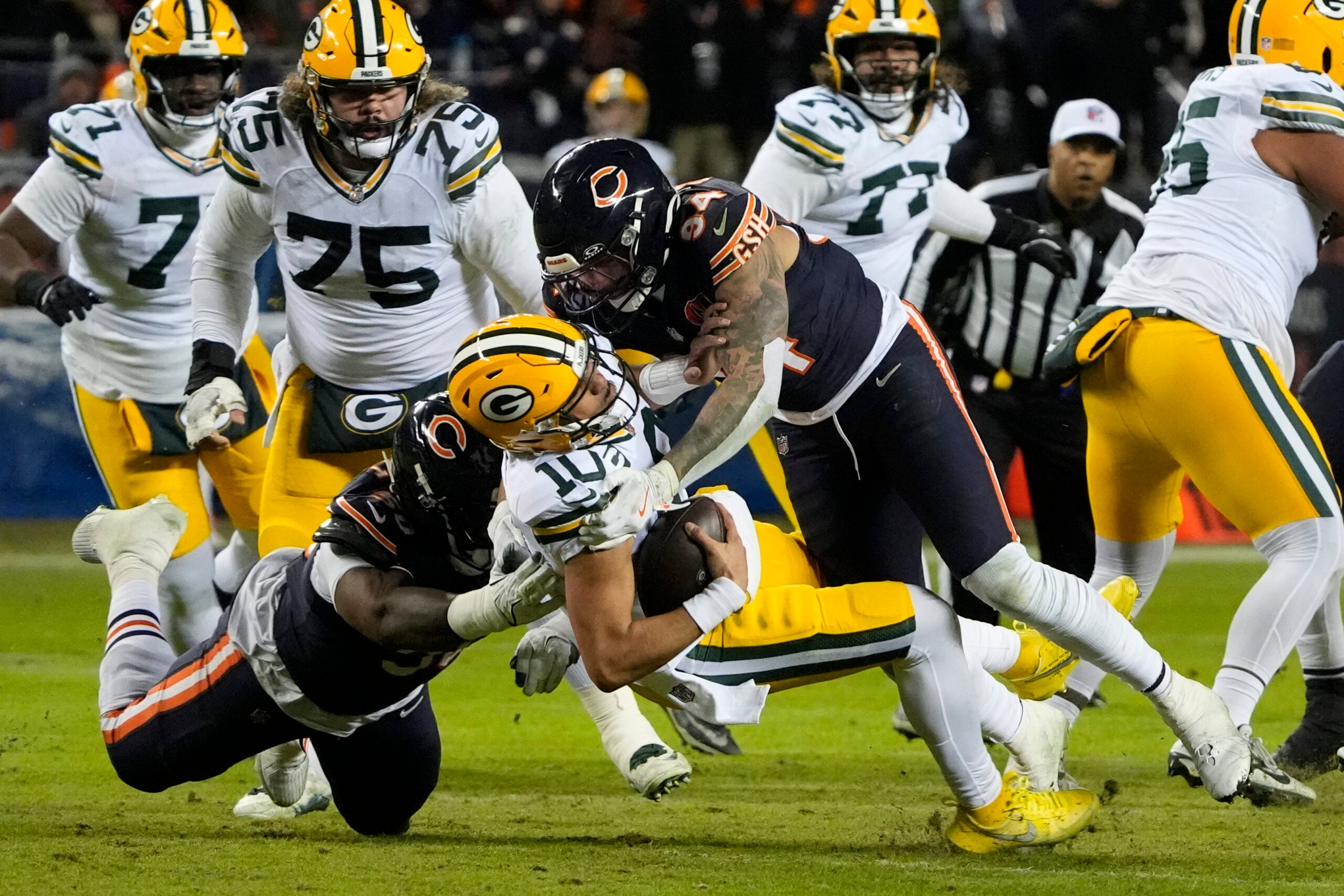 Jan 10, 2026; Chicago, IL, USA; Green Bay Packers quarterback Jordan Love (10) is sacked by Chicago Bears defensive end Austin Booker (94) during the first half of an NFC Wild Card Round game at Soldier Field.