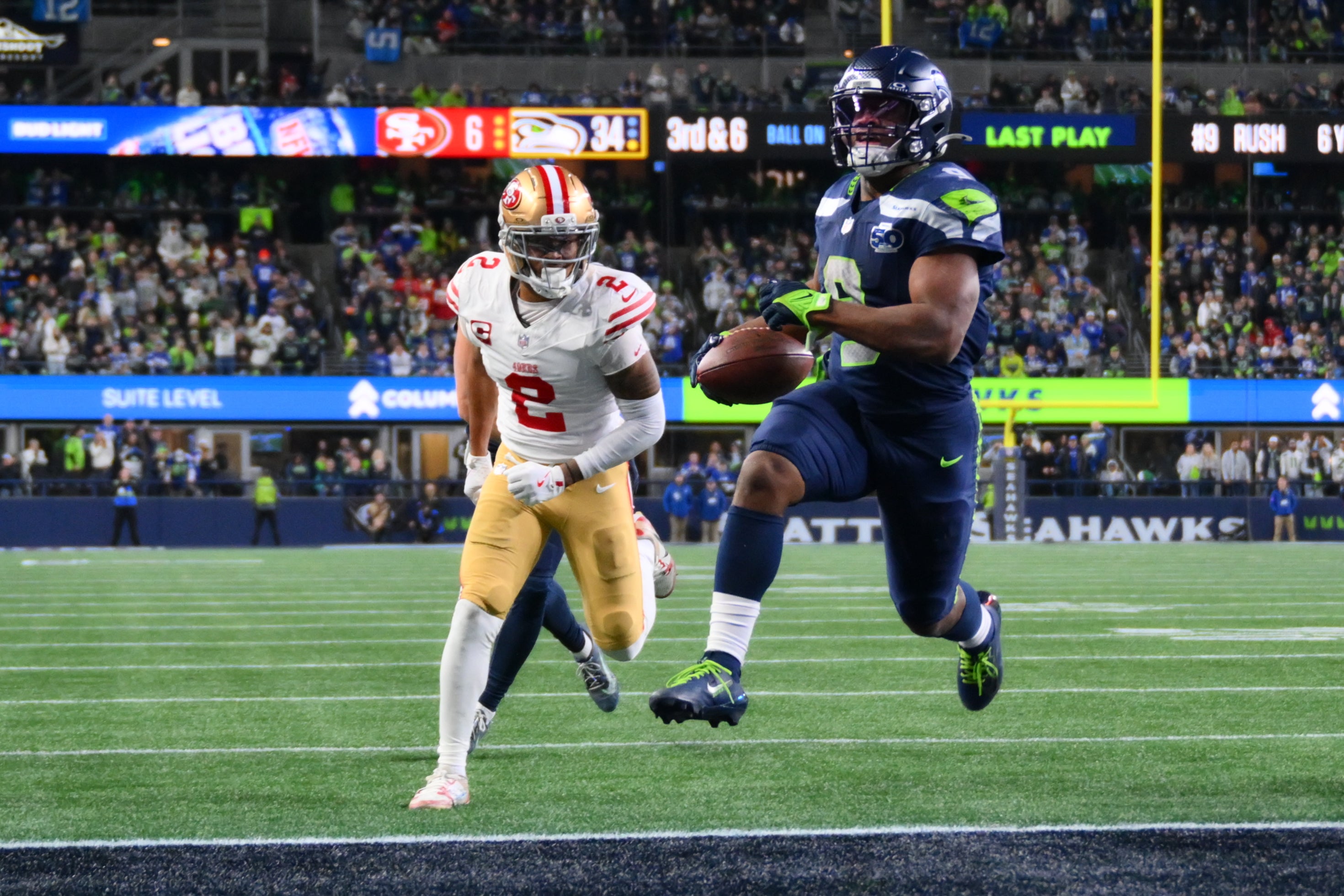 Jan 17, 2026; Seattle, WA, USA; Seattle Seahawks running back Kenneth Walker III (9) carries the ball for a touchdown as San Francisco 49ers cornerback Deommodore Lenoir (2) trails on the play during the second half in an NFC Divisional Round game at Lumen Field.
