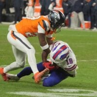 Denver Broncos cornerback Ja'quan McMillian reaches in on Buffalo Bills wide receiver Brandin Cooks who has the ball and whose knee is on the ground during overtime at Empower FIeld at Mile High in Denver, Colorado on Jan. 17, 2026.