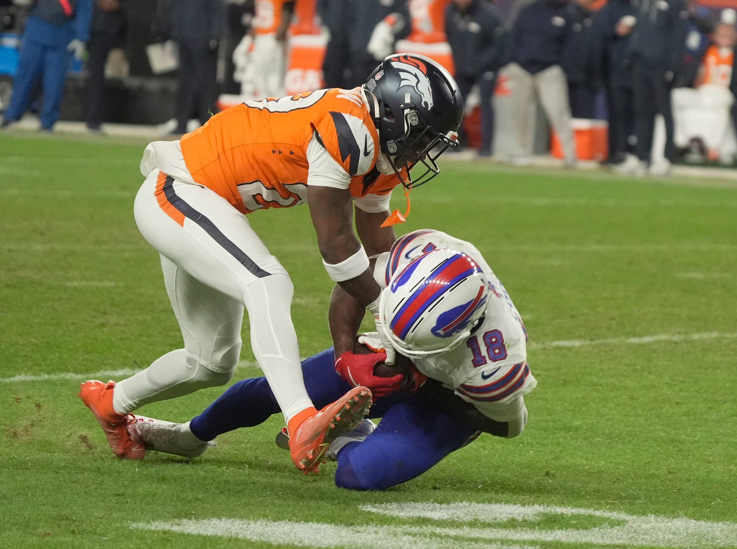 Denver Broncos cornerback Ja'quan McMillian reaches in on Buffalo Bills wide receiver Brandin Cooks who has the ball and whose knee is on the ground during overtime at Empower FIeld at Mile High in Denver, Colorado on Jan. 17, 2026.