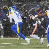 Jan 18, 2026; Chicago, IL, USA; Los Angeles Rams cornerback Cobie Durant (14) runs with the ball against Chicago Bears wide receiver DJ Moore (2) after intercepting a pass thrown by quarterback Caleb Williams (not pictured) during the first quarter of an NFC Divisional Round game at Soldier Field.