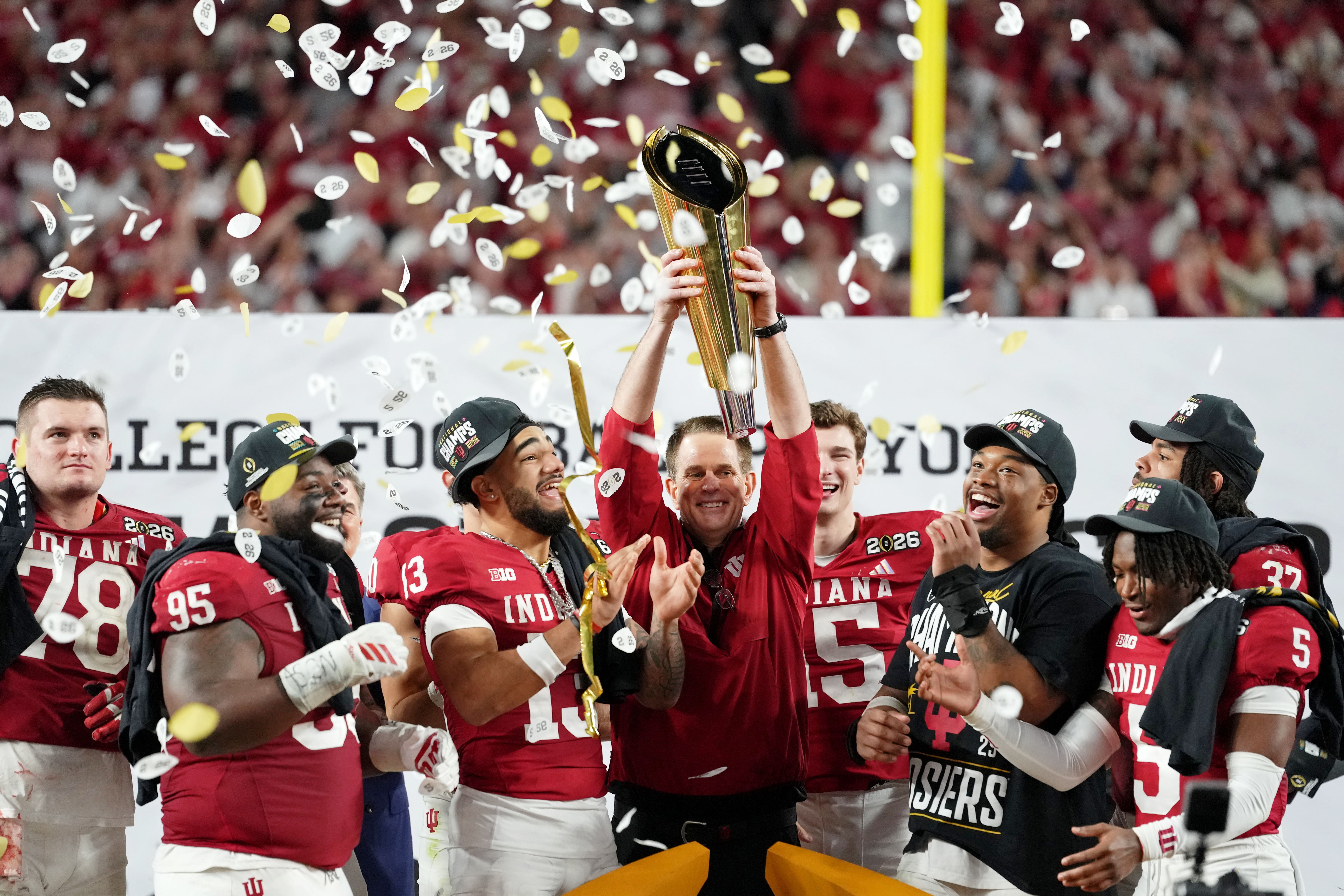 Indiana head coach Curt Cignetti lifts the national championship trophy above his head