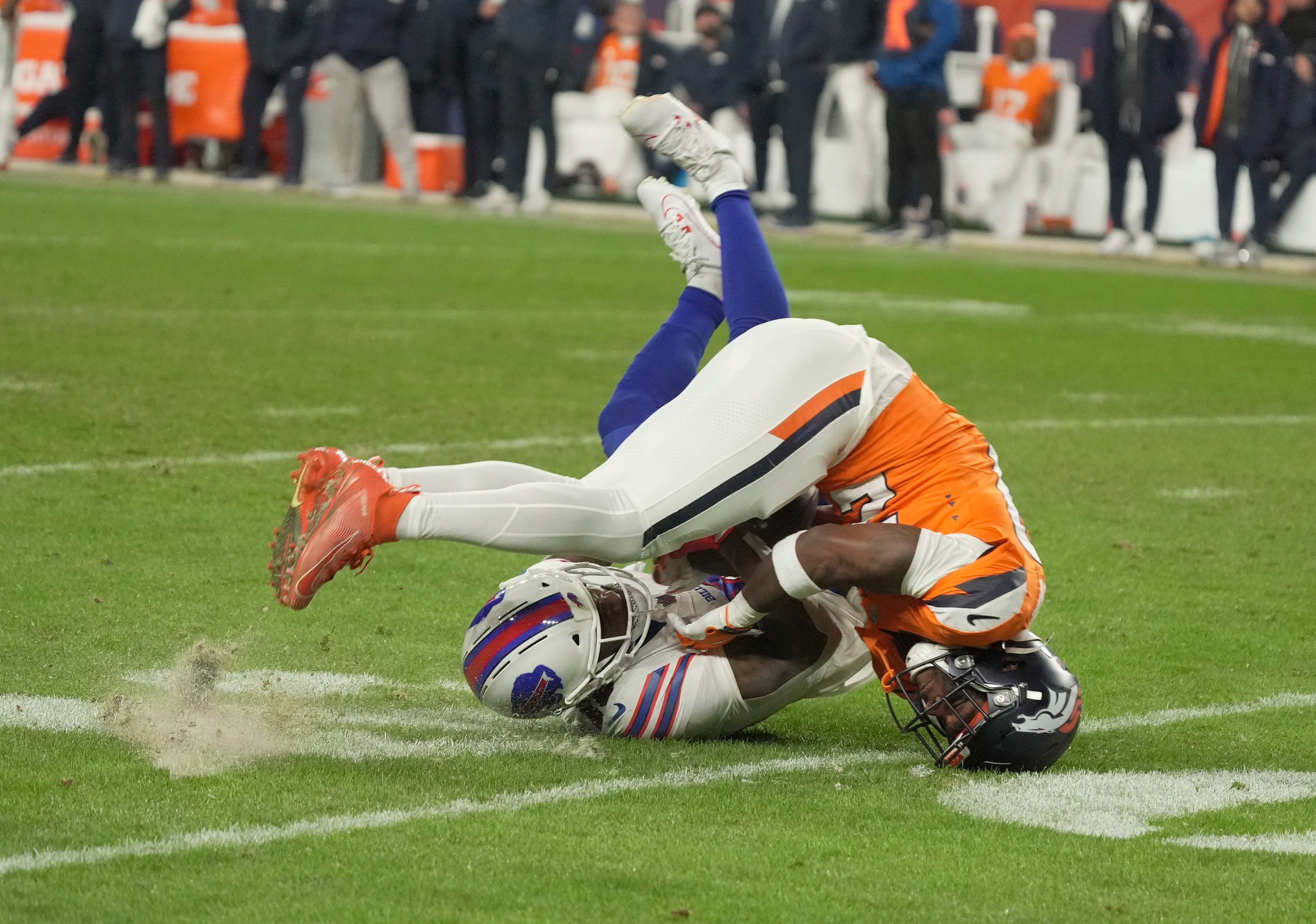 Buffalo Bills wide receiver Brandin Cooks starts to lose control of the ball after getting his by Denver Broncos cornerback Ja'quan McMillian and rolling over during overtime at Empower Field at Mile High in Denver, Colorado on Jan. 17, 2026. McMillian came up with the ball and officials called it in Denver’s favor as an interception.