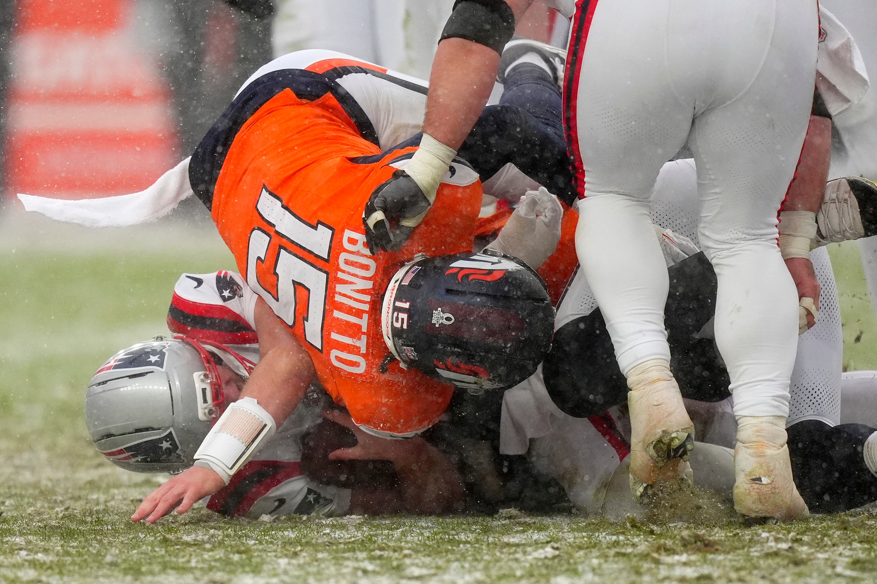 Jan 25, 2026; Denver, CO, USA; Denver Broncos linebacker Nik Bonitto (15) tackles New England Patriots quarterback Drake Maye (10) during the second half in the 2026 AFC Championship Game at Empower Field at Mile High.
