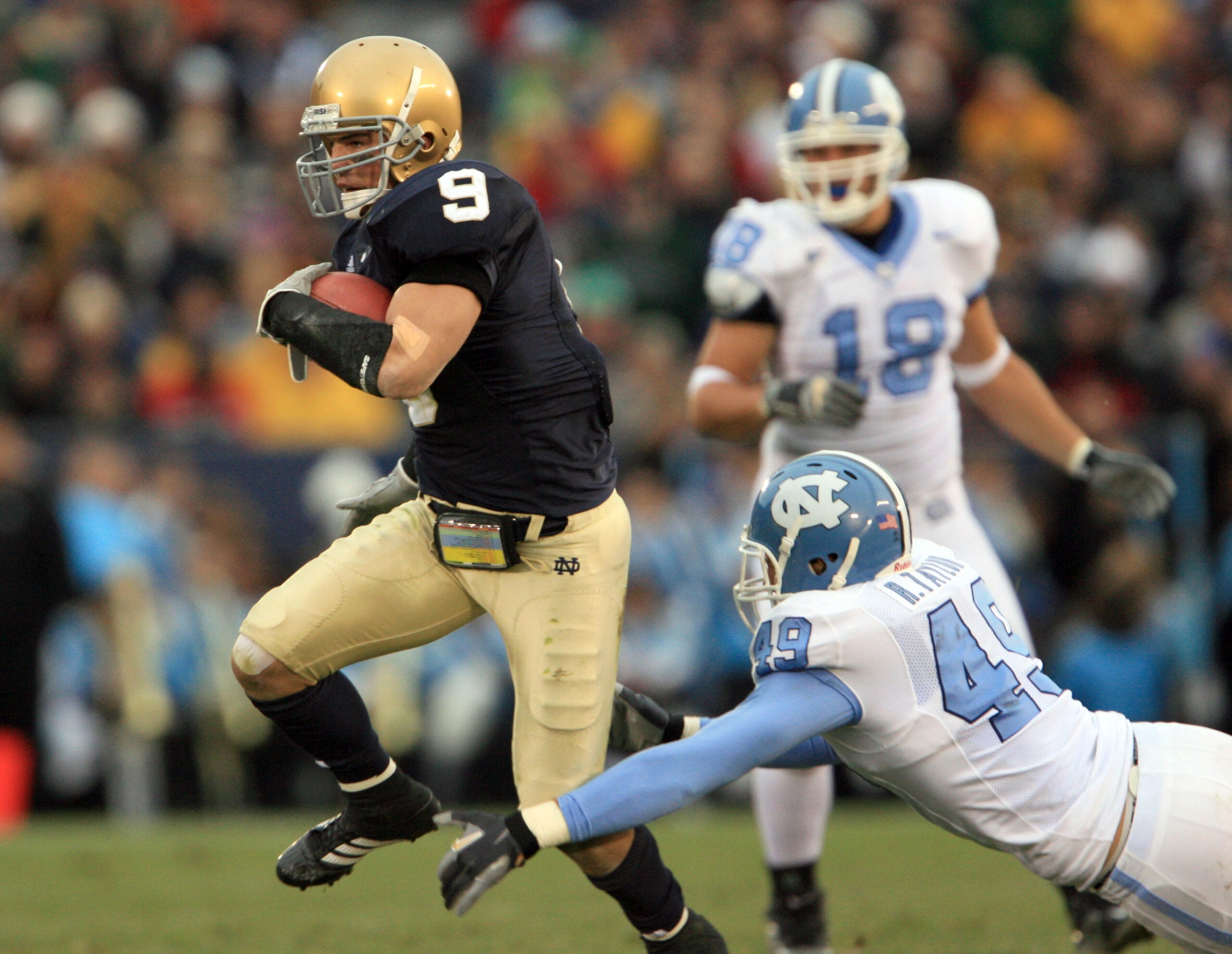 Nov. 4, 2006; South Bend, IN, USA; Notre Dame Fighting Irish defensive back (9) Tom Zbikowksi runs a punt back for a second quarter touchdown as North Carolina Tar Heels defender (49) Ryan Taylor attempts to tackle. Mandatory Credit: Matt Cashore-USA TODAY Sports © copyright (2006) Matt Cashore