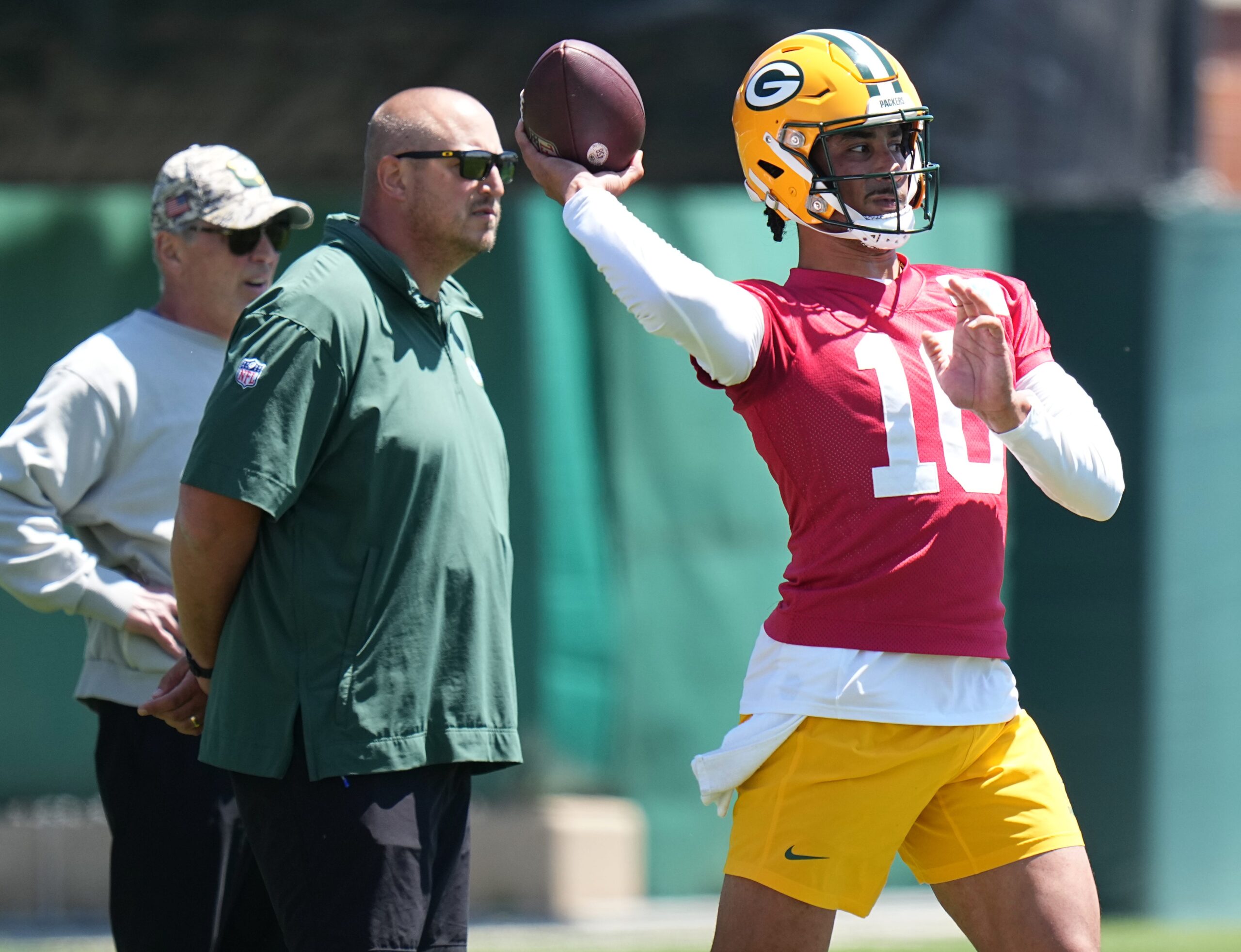 As Green Bay Packers offensive coordinator Adam Stenavich looks on, quarterback Jordan Love (10) throws a pass during organized team activities Wednesday, May 29, 2024 in Green Bay, Wisconsin.