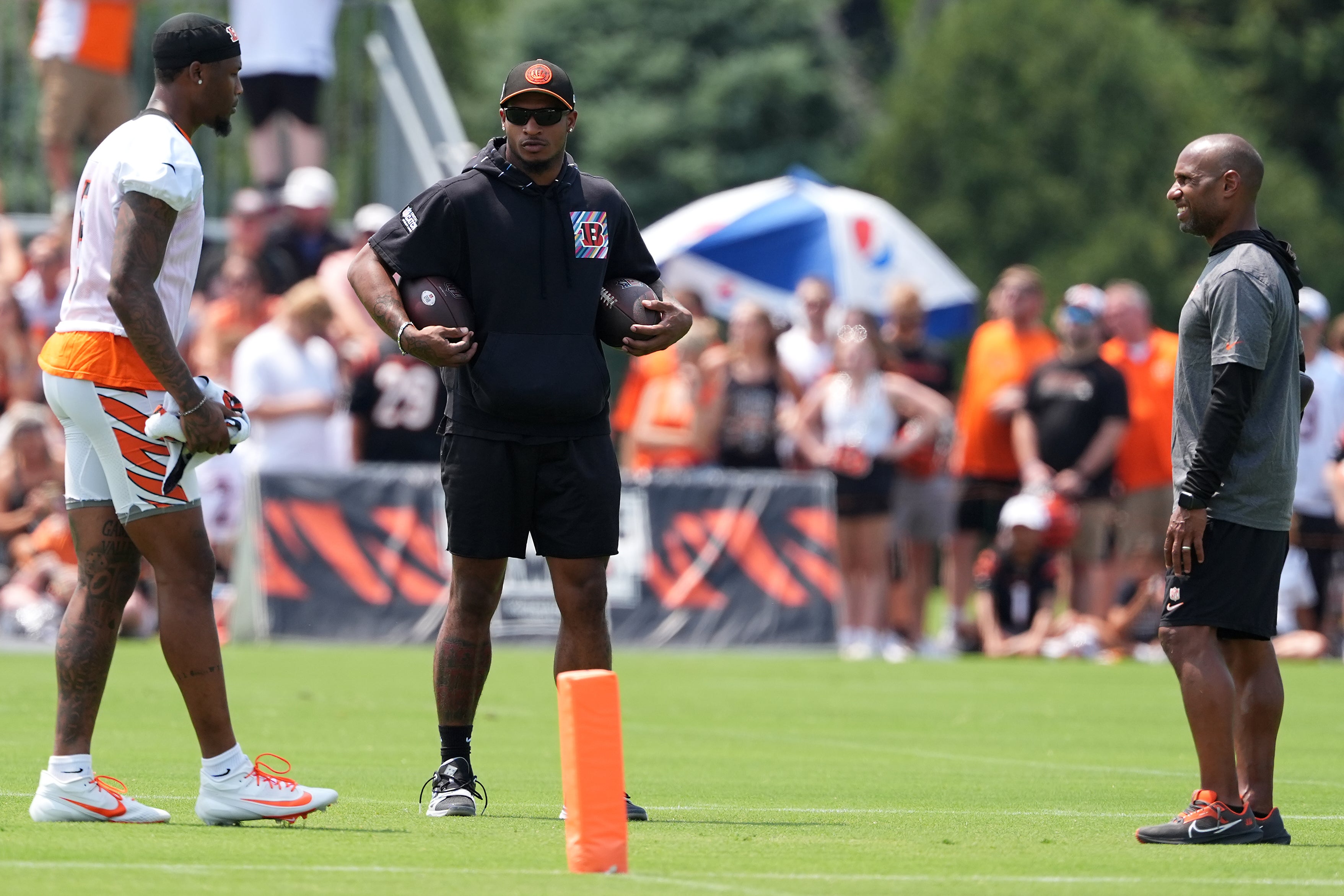 Jul 26, 2024; Cincinnati, OH, USA; Cincinnati Bengals wide receiver Ja'Marr Chase (middle) talks with wide receiver Tee Higgins (left) and wide receivers coach Troy Walters during training camp practice at Kettering Health Practice Fields.